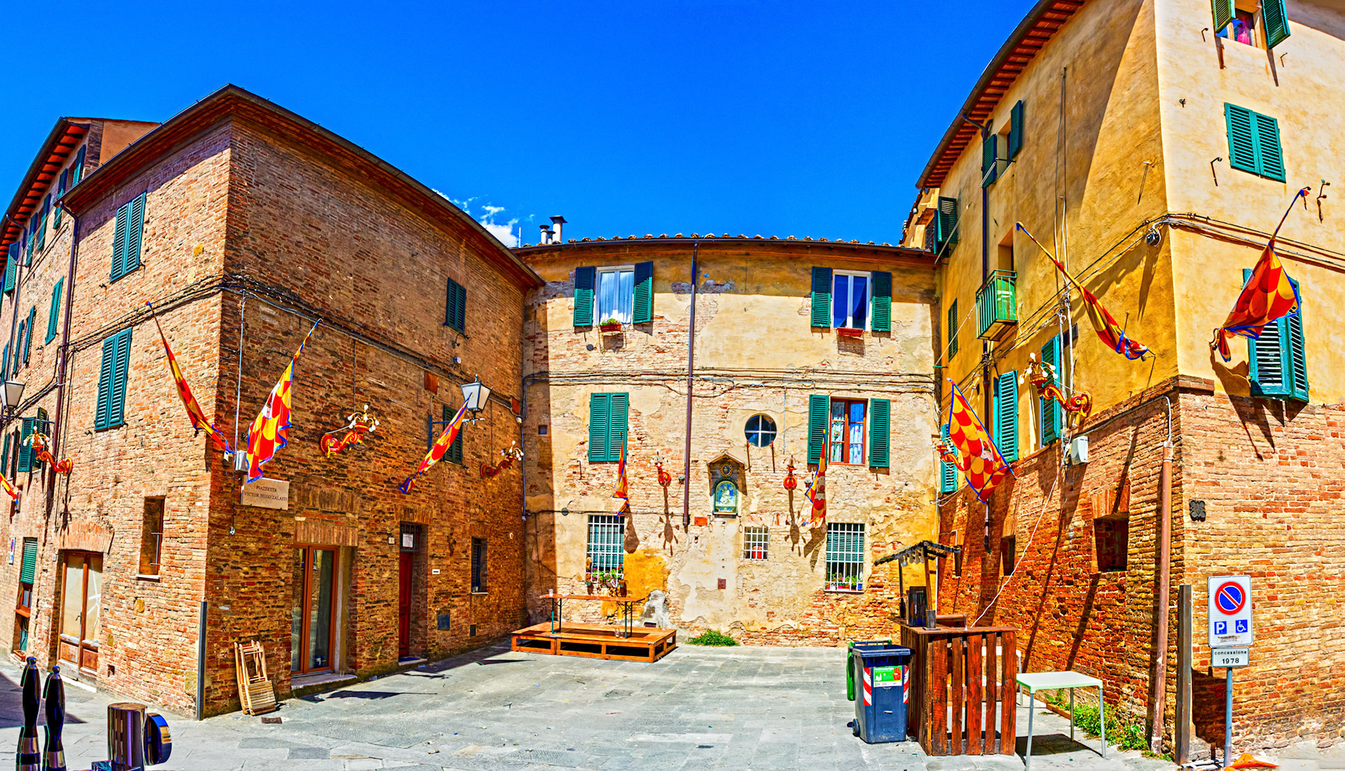 Street scene in Siena with Palio decorations and prep for street meal - 26 June 2024
