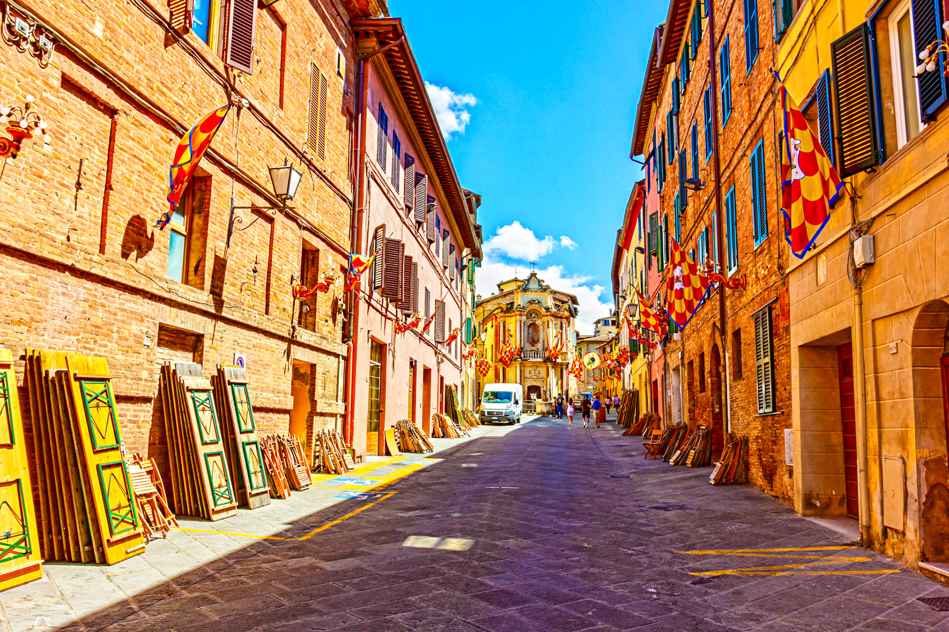 Street scene in Siena with Palio decorations and prep for street meal - 26 June 2024