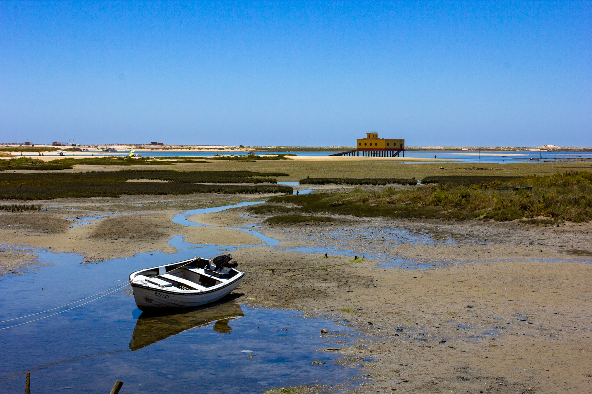 Small boat in Fuseta, with the lifeboat house behind.