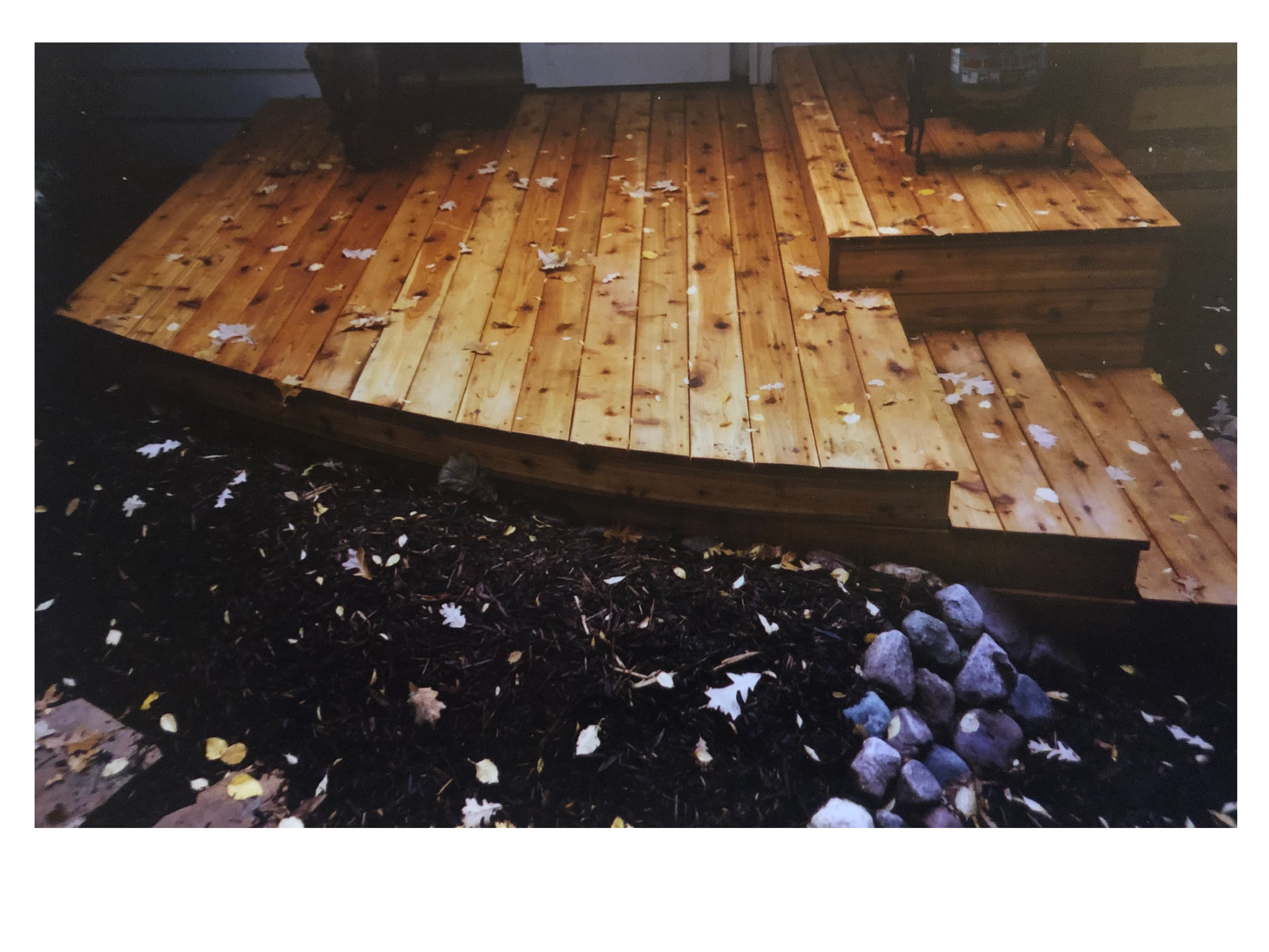 Cedar deck designed as an egress to the yard with minimal disruption of view, now railing.
