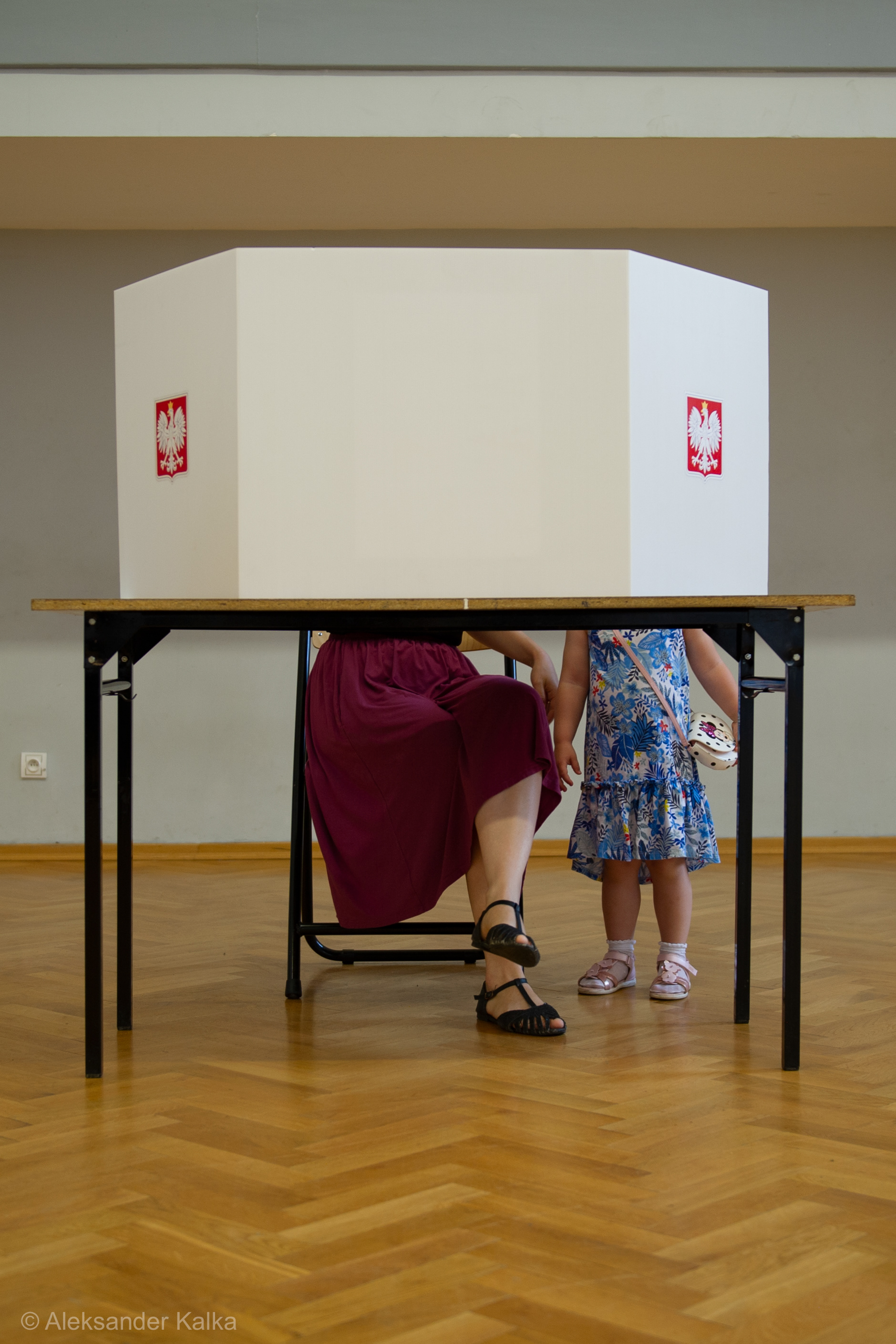 A mother with her daughter is seen behind a polling tabel during the presidential elections in Poland on June 28, 2020 in Warsaw, Poland.