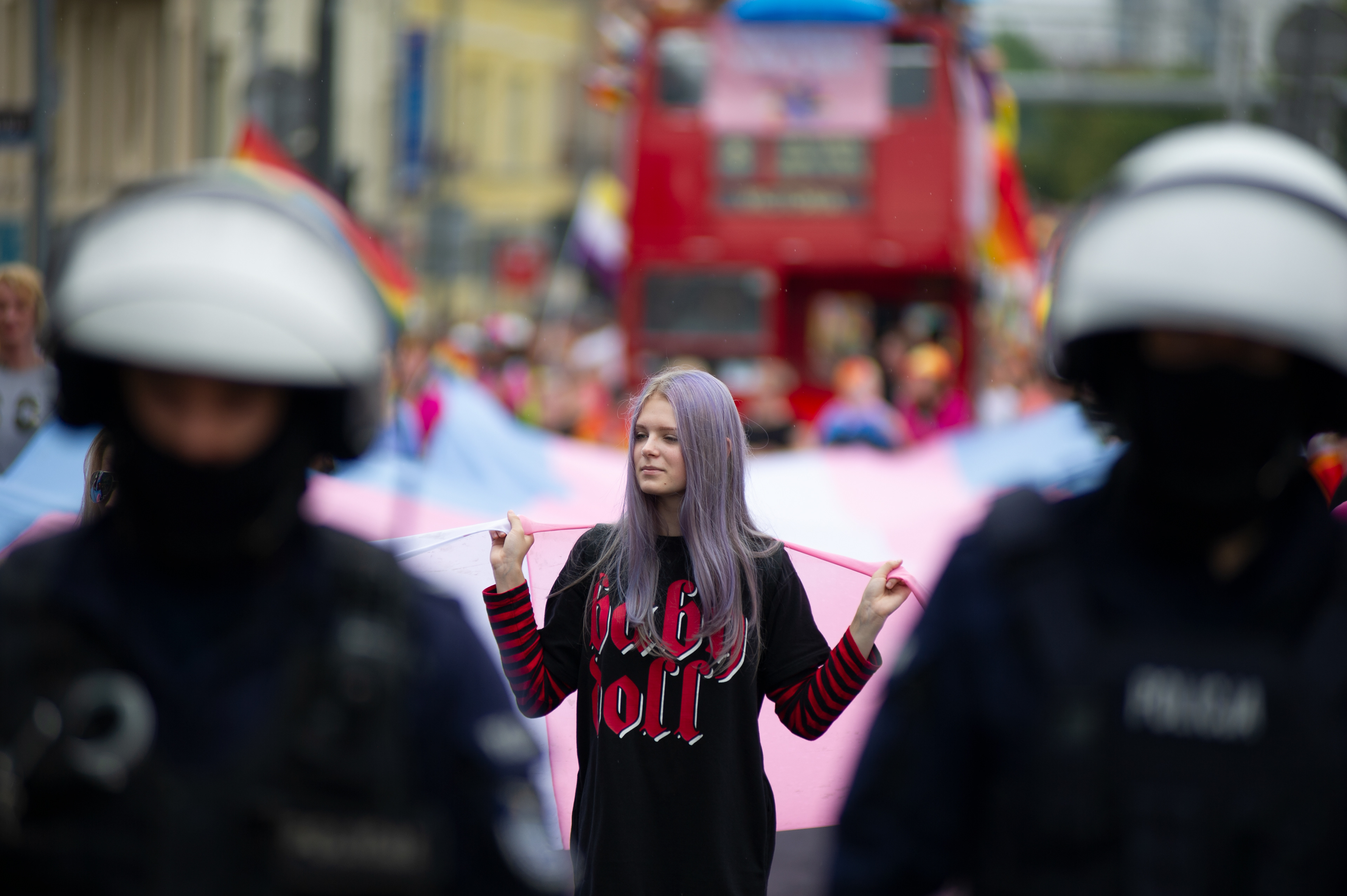 A member of the LGBTIQ community holds an over-sized flag as she is pictured behind riot police officers during the Poznań Pride parade on July 6, 2019 in Poznań, Poland. 