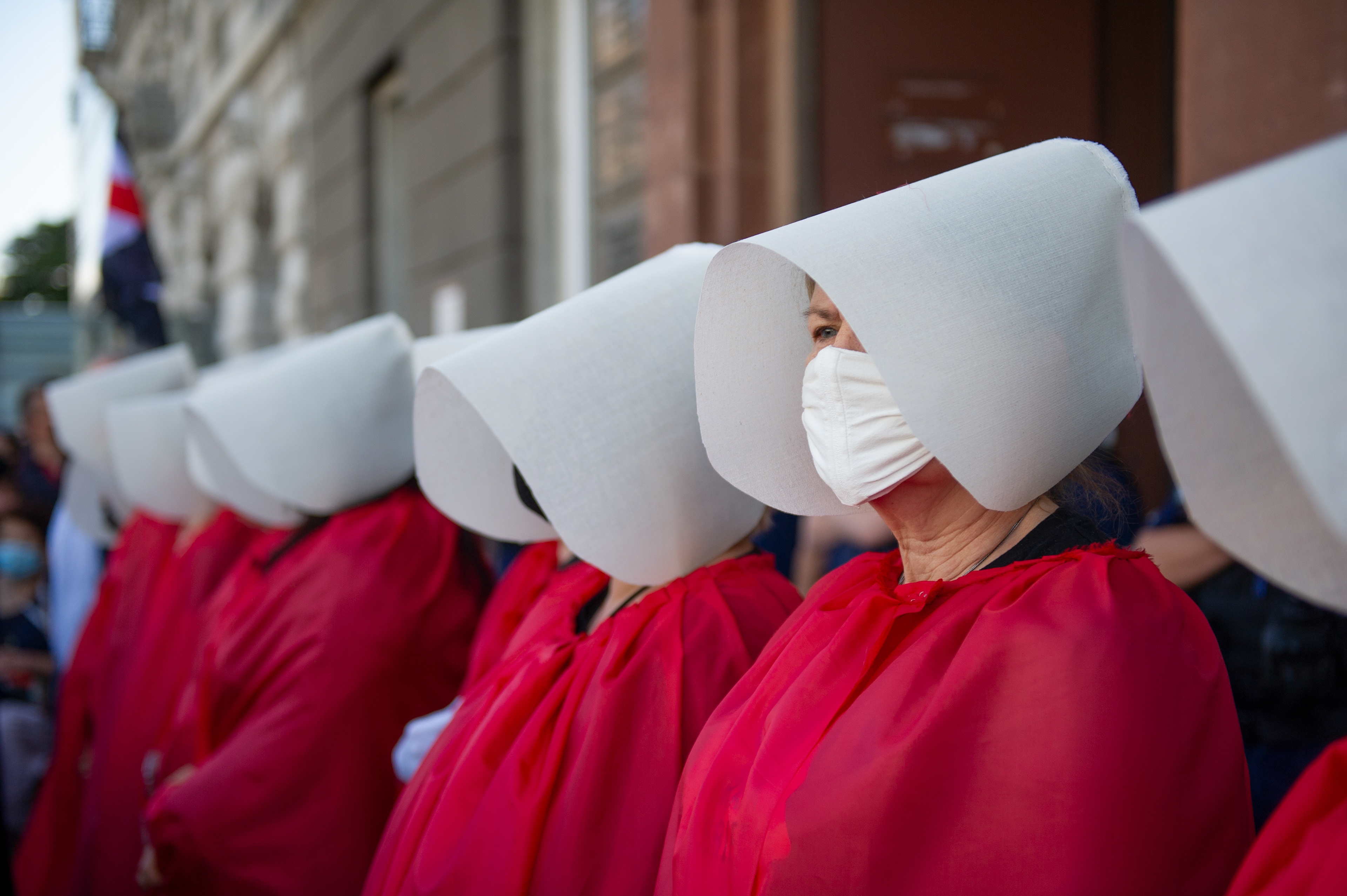Demonstrators wearing protective face masks are dressed as the Handmaids from the dystopian novel The Handmaid's Tale from the Canadian author Margaret Atwood perform during an anti-domestic violence protest on July 24, 2020 in Warsaw, Poland