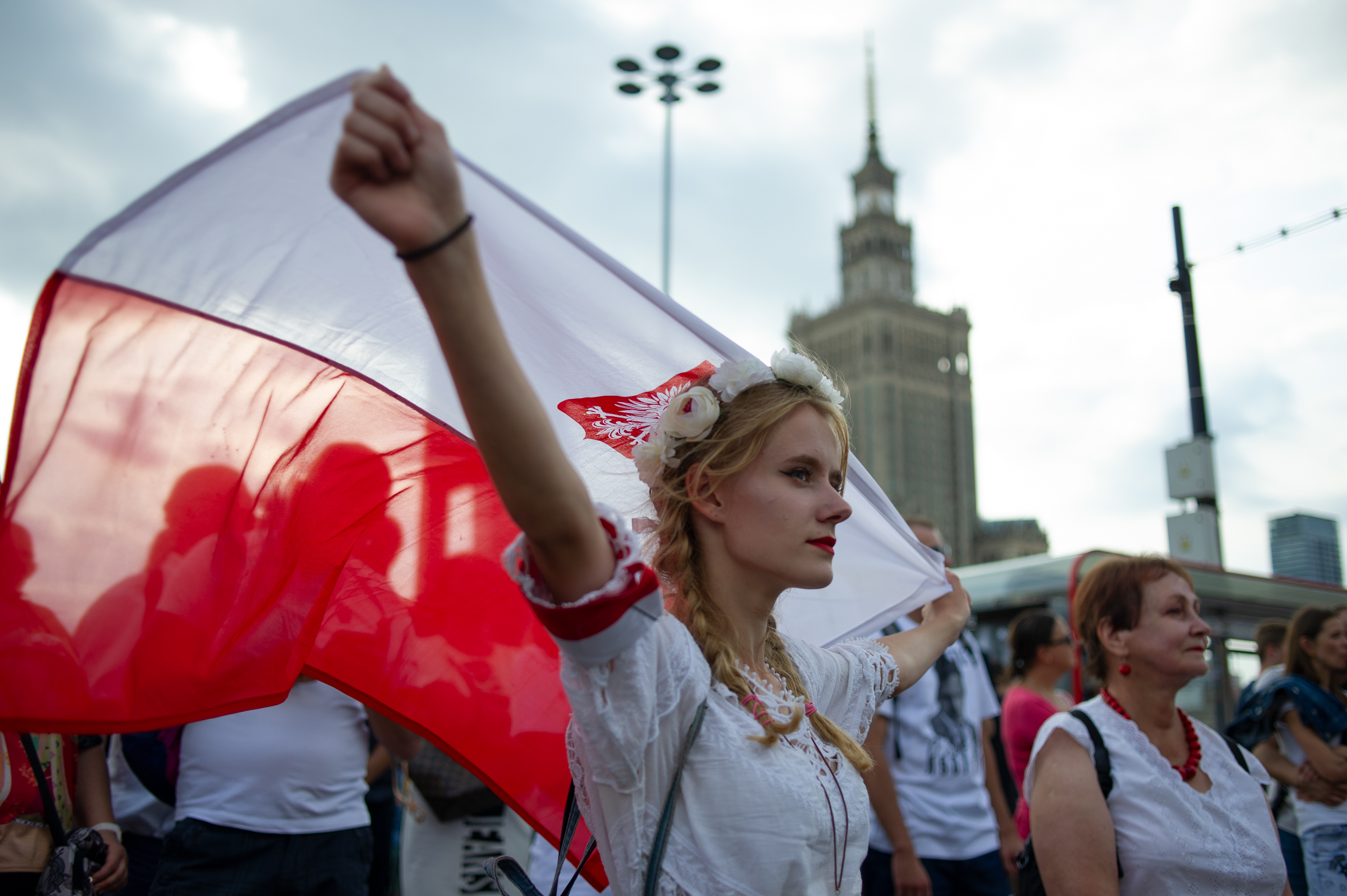 A woman wearing a traditional dress holds a Polisg flag during celebration of the 75th anniversary of the Warsaw uprising on Aug 1, 2019 in Warsaw, Poland