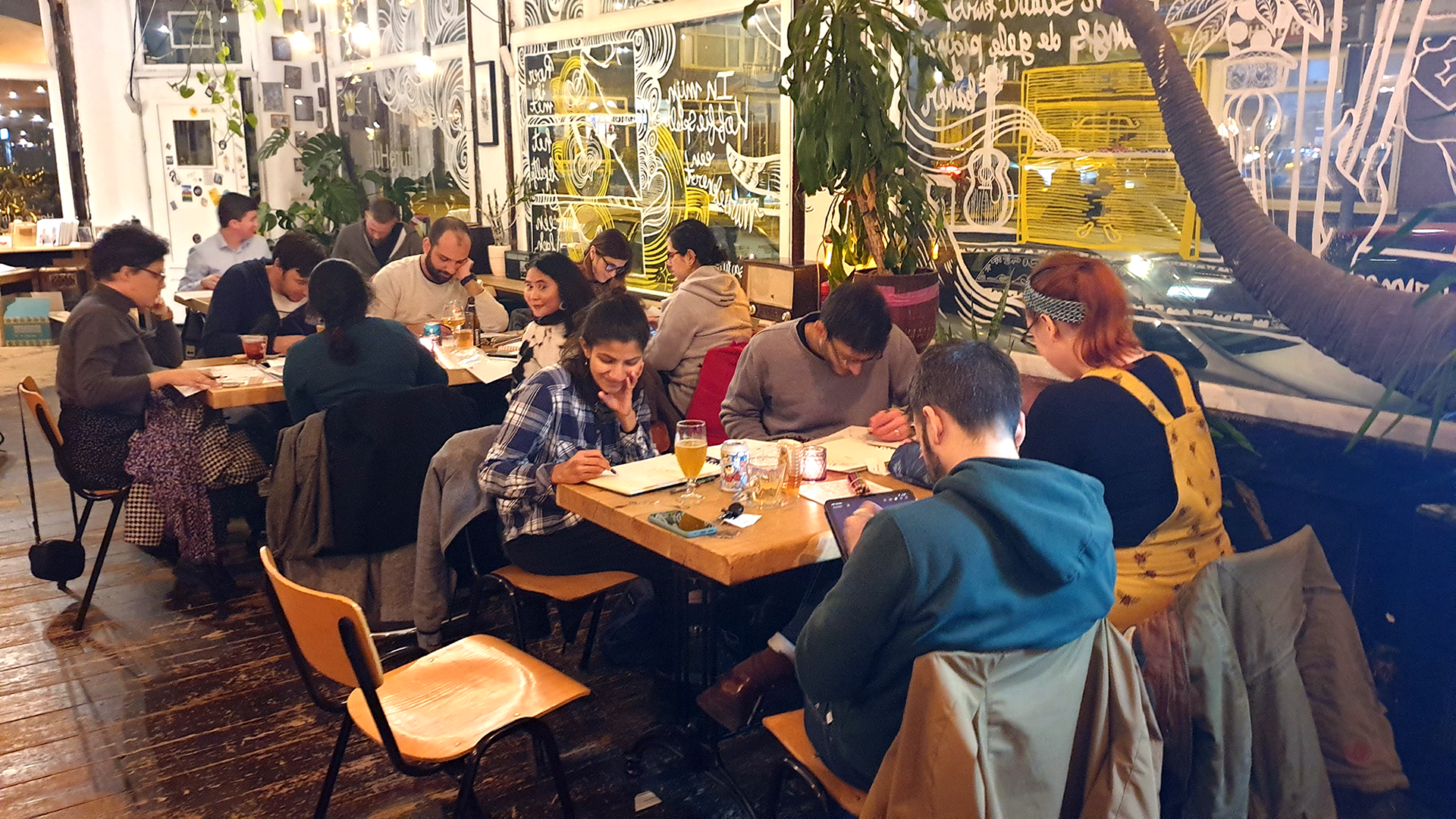 A café filled with people, happily drawing with each other.
