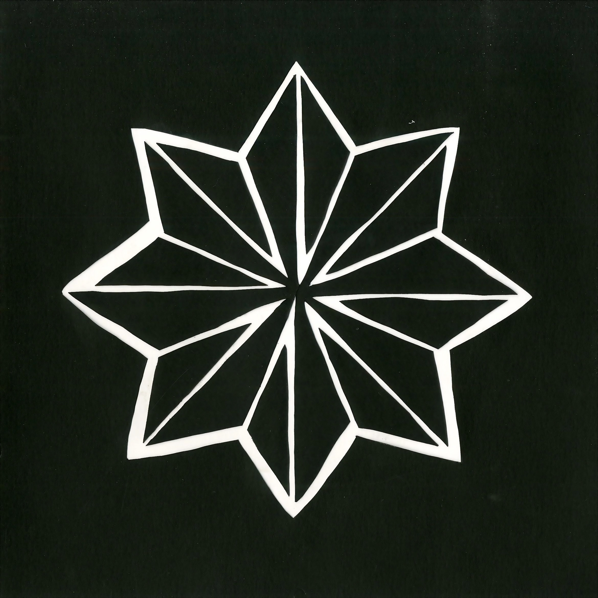 black and white paper cut-out of symmetrical eight-pointed star
