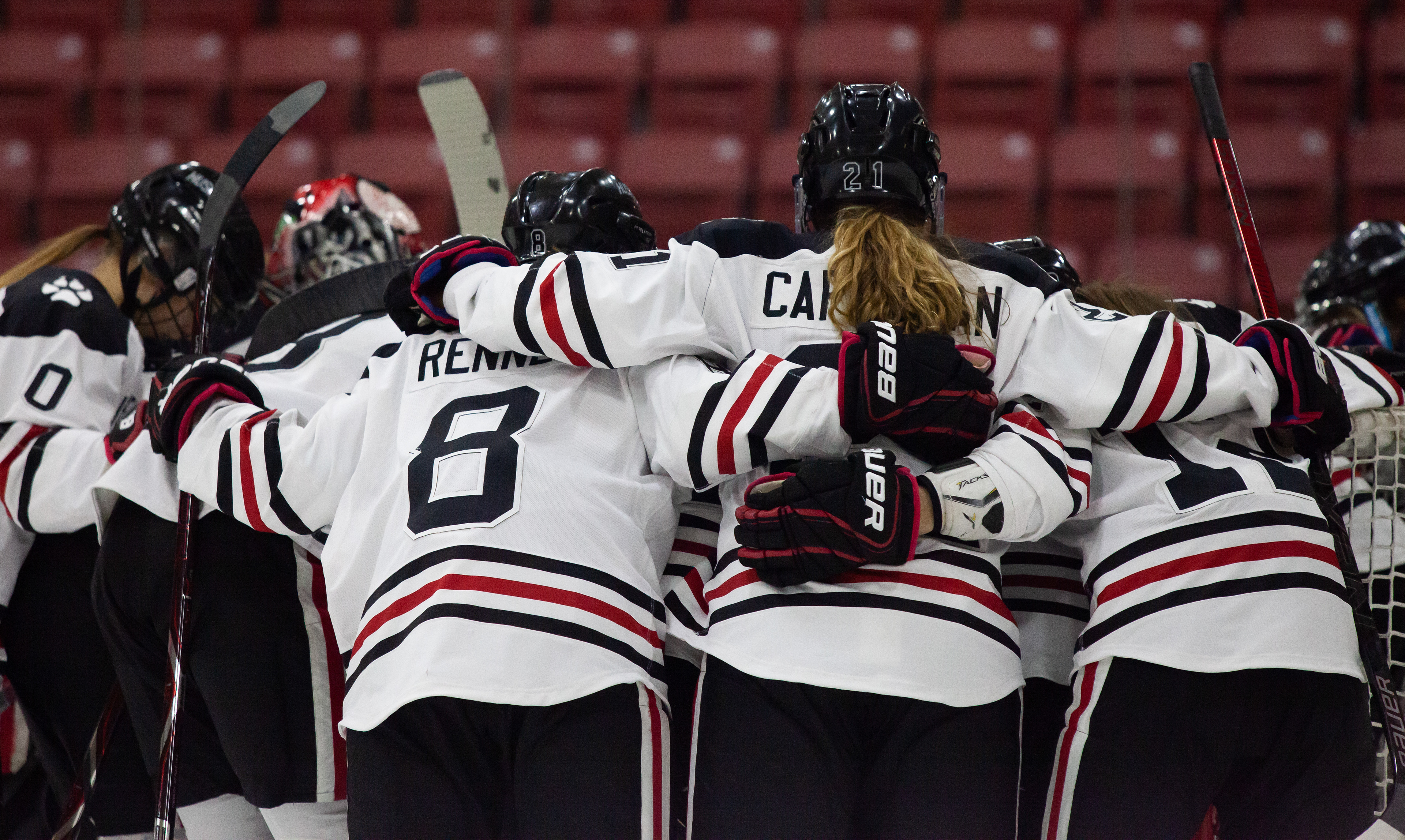 The Northeastern University Huskies huddle out on the ice during the final game of the 2019 Women's Beanpot.