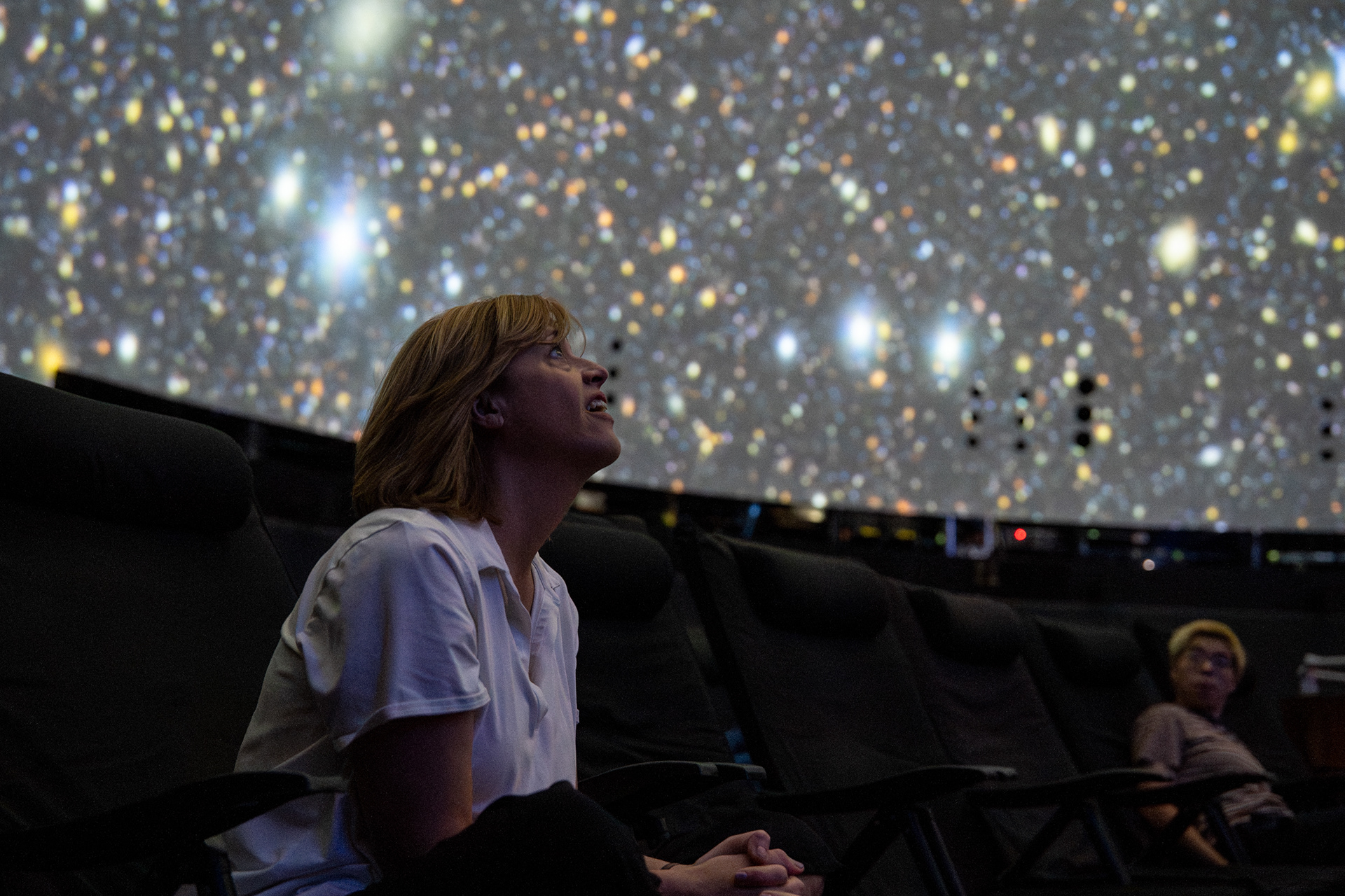 A guest sits in awe at the first images from Vera C. Rubin Observatory in Chile during the Rochester Music and Science Center’s “Rubin First Look Watch Party” on Mon, June 23, 2025, in Rochester, N.Y. Natasha Kaiser / WXXI News