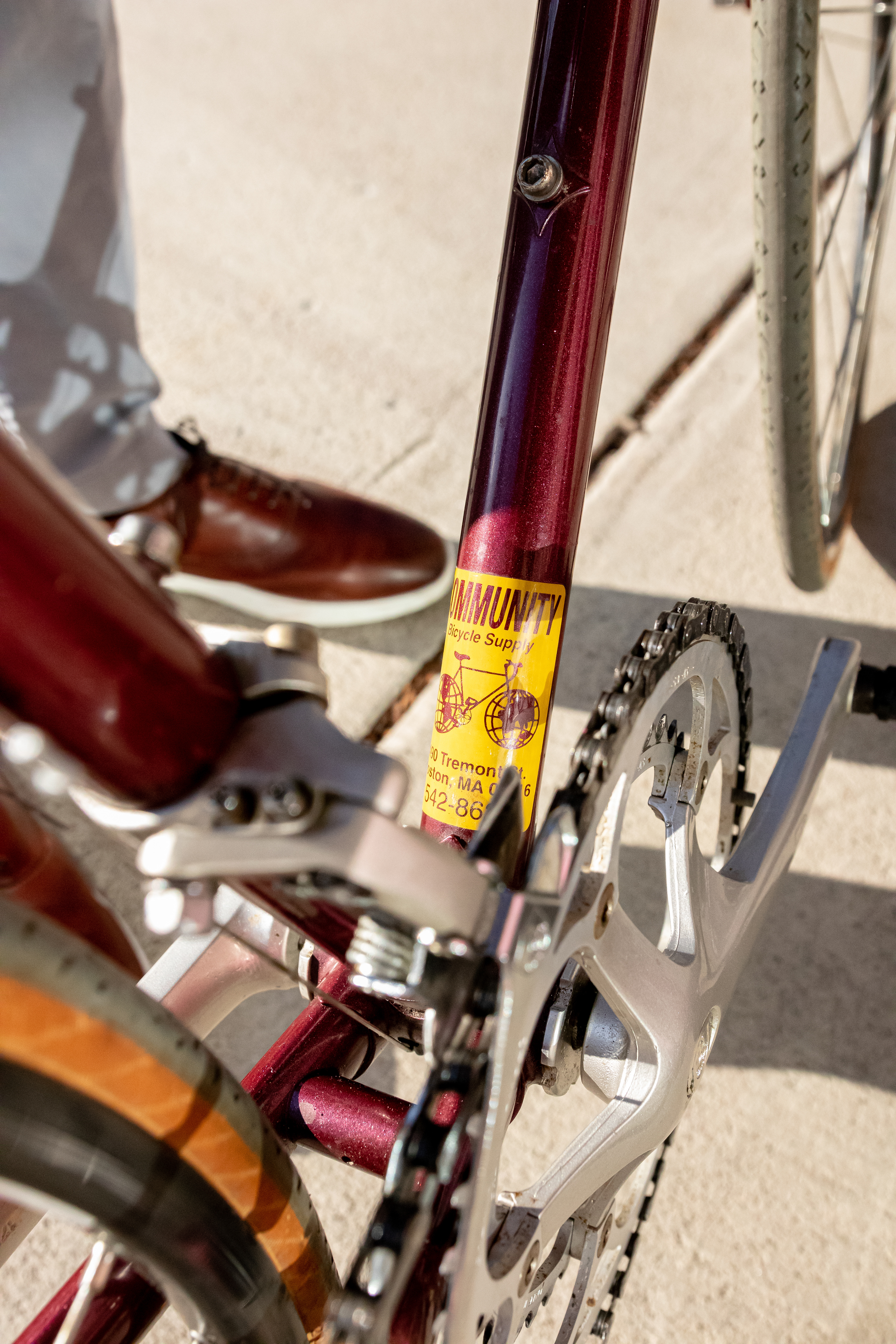 A bike recently purchased by a young couple bears an old sticker of Community Bike Supply, April 22, 2022 in Boston, Massachusetts. The bike had been purchased at the shop years ago, and when the mechanics pointed out the sticker, the owner said "it was destiny" for the bike to be brought in for a tune (Ryan Li).