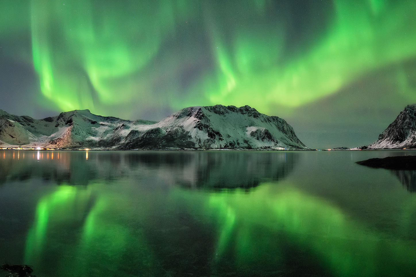 Aurora boreale riflessa su lago in Islanda