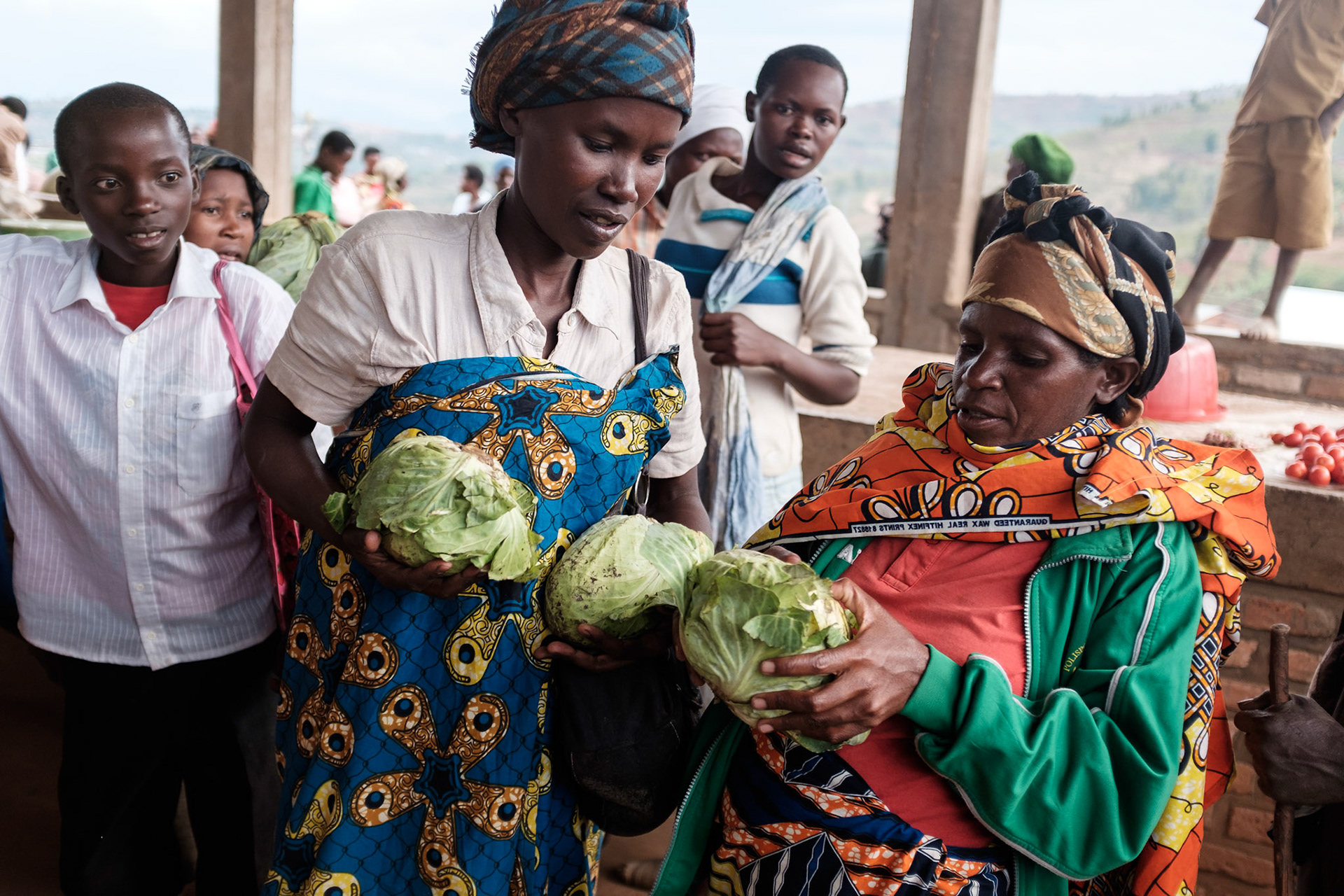 Immaculate selects vegetables for dinner at the local market. The market is located at the top of a hill in another village about 30 minutes walk from Kasebuturanyi.