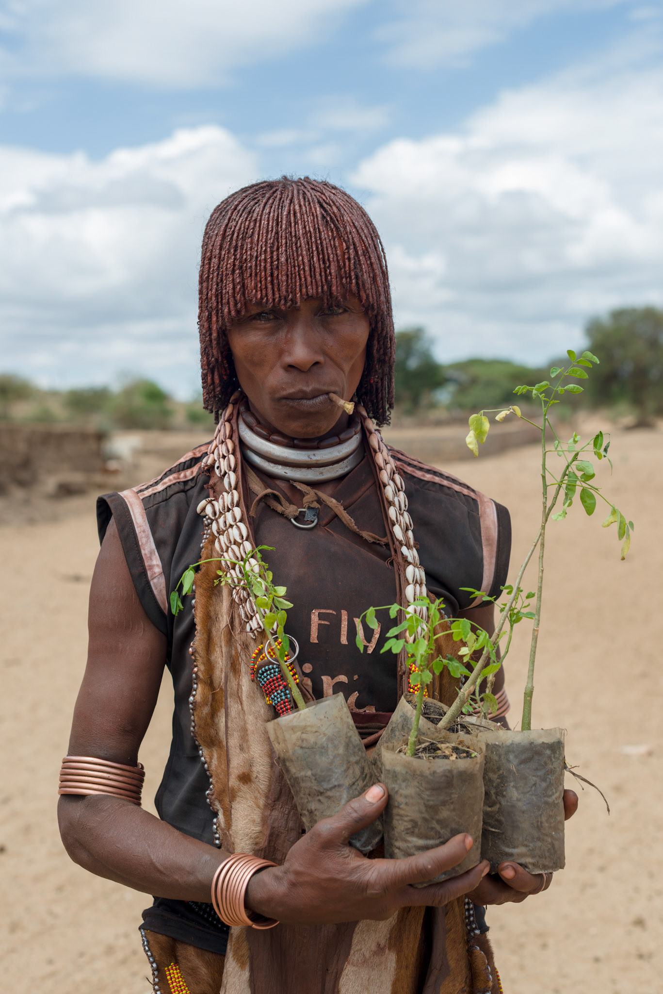 A Hamer woman from the Asile kebele with her moringa plants. The seed pods from moringa trees are used for food and as a cash crop.