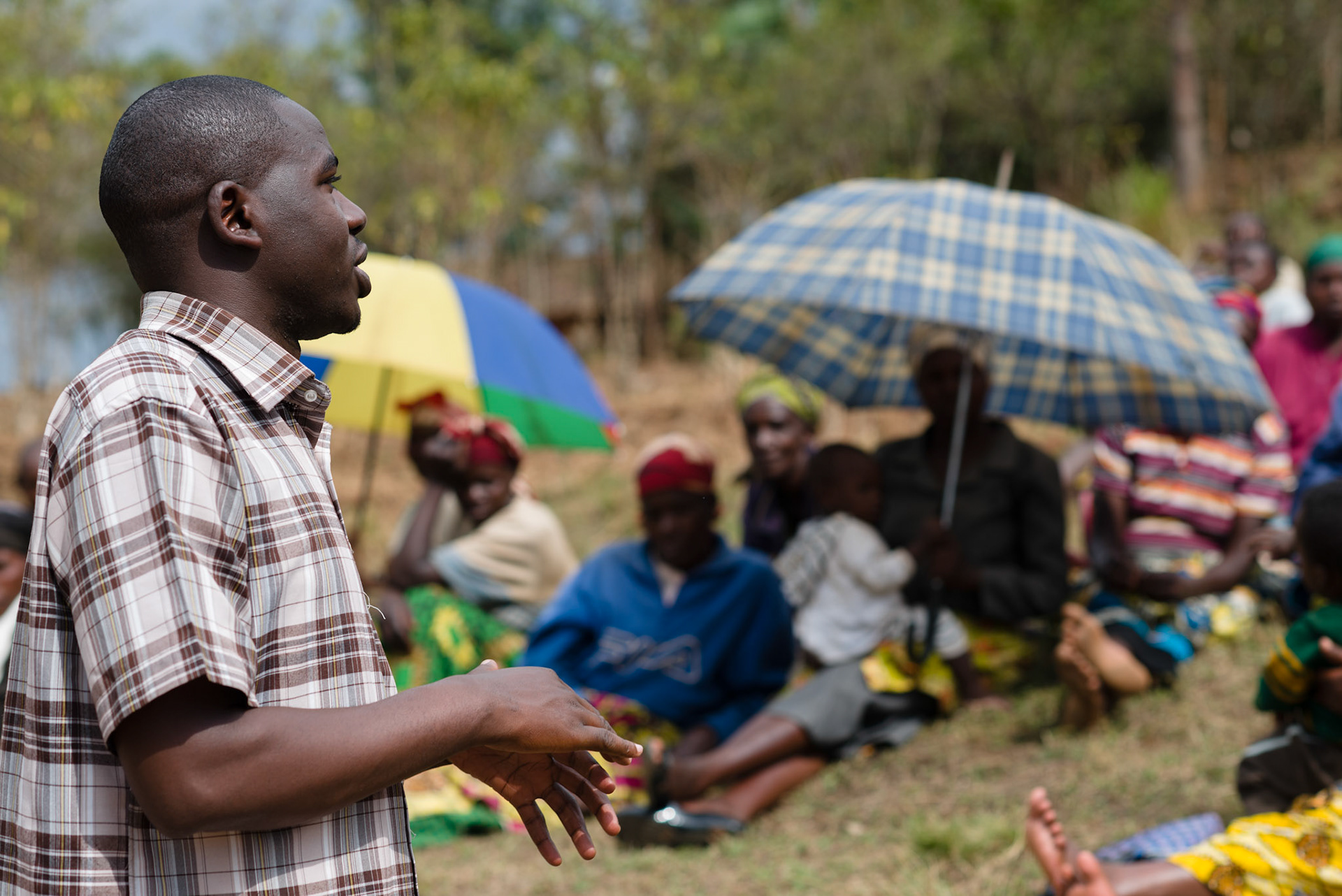 Emmanuel, a field coordinator from AEE, explains self-help groups to the women of Kasebuturanyi.
