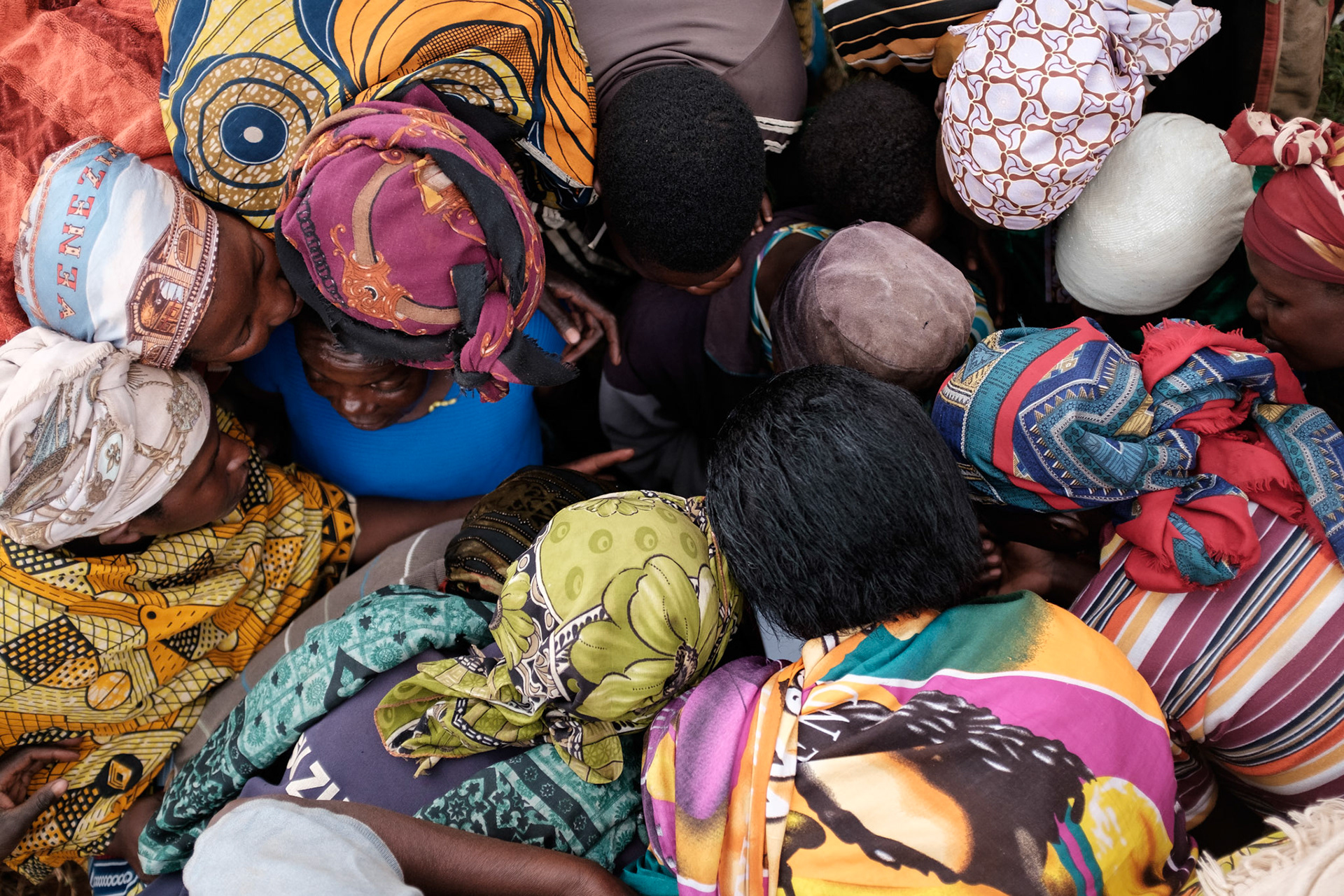 Women of a newly formed group huddle tightly while their names are being recorded. They also have to choose a name for the group. The choices are usually something inspiring for the women.