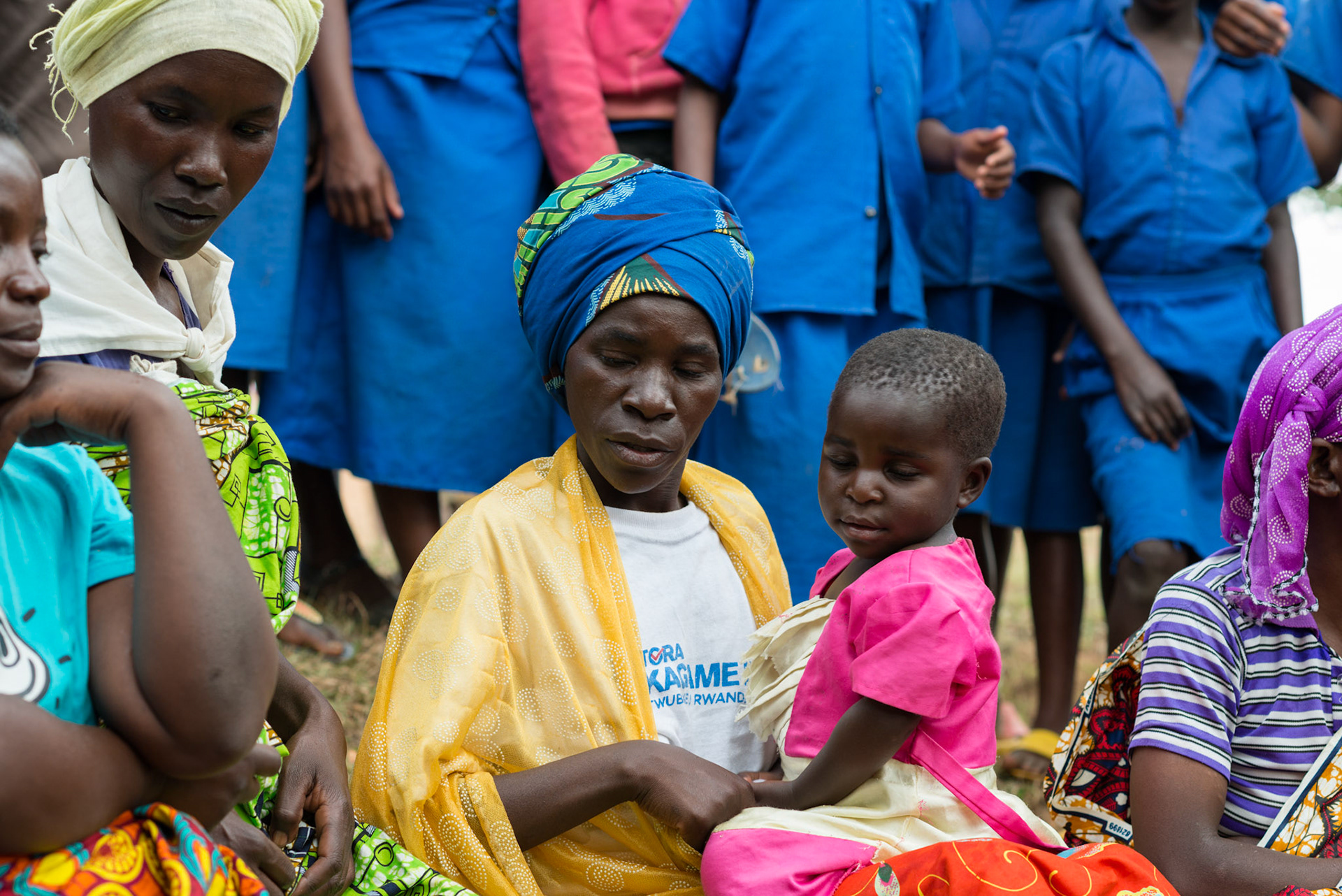Philomene and her daugher Claire sit with Philomene's group, a year after she joined.