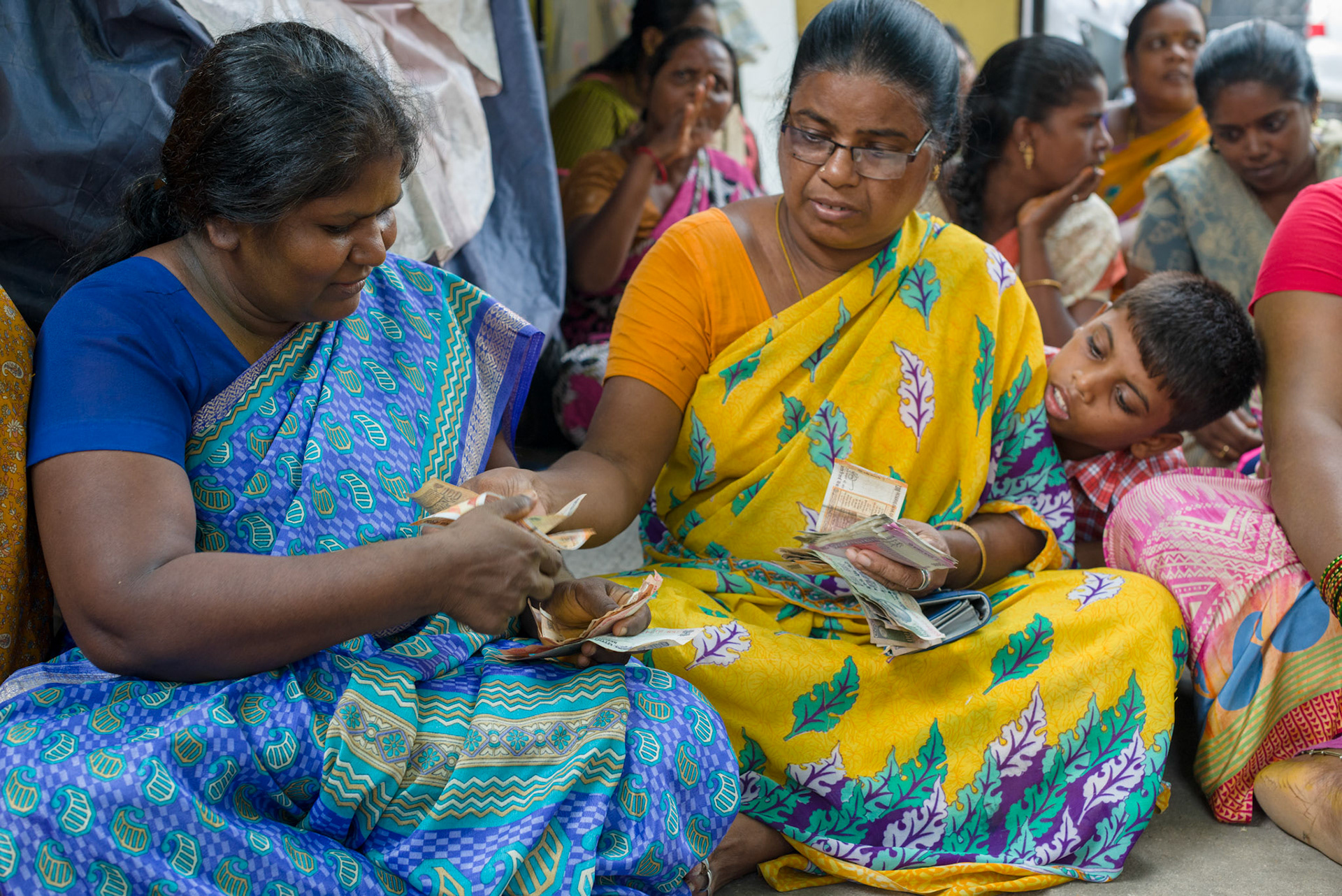 The leader of a self-help group distributes the loans for the week.