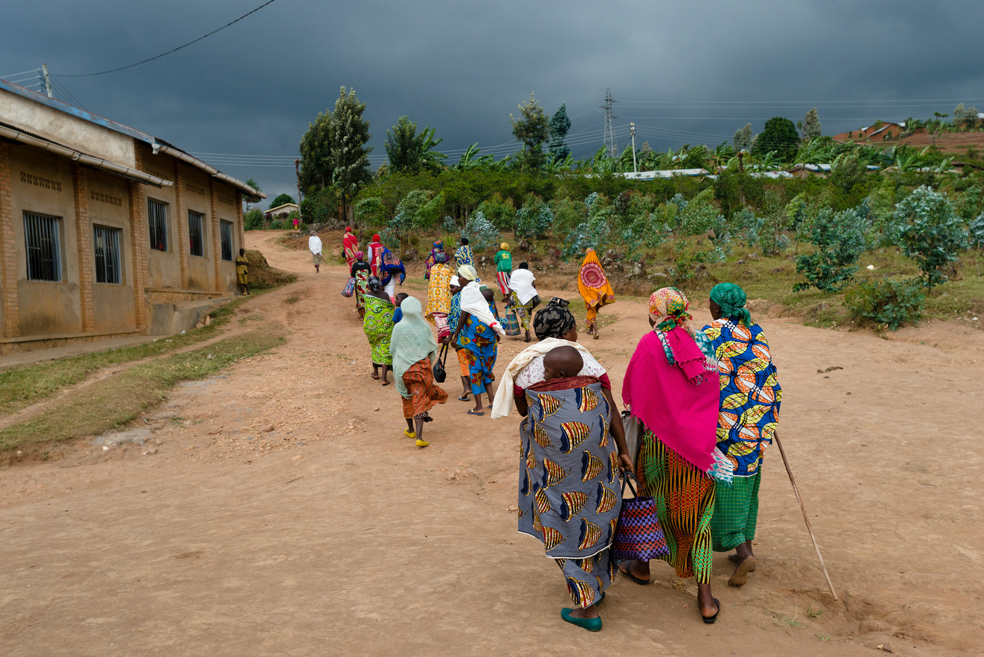 With the sky promising rain, the women head to a nearby house for their weekly meeting.