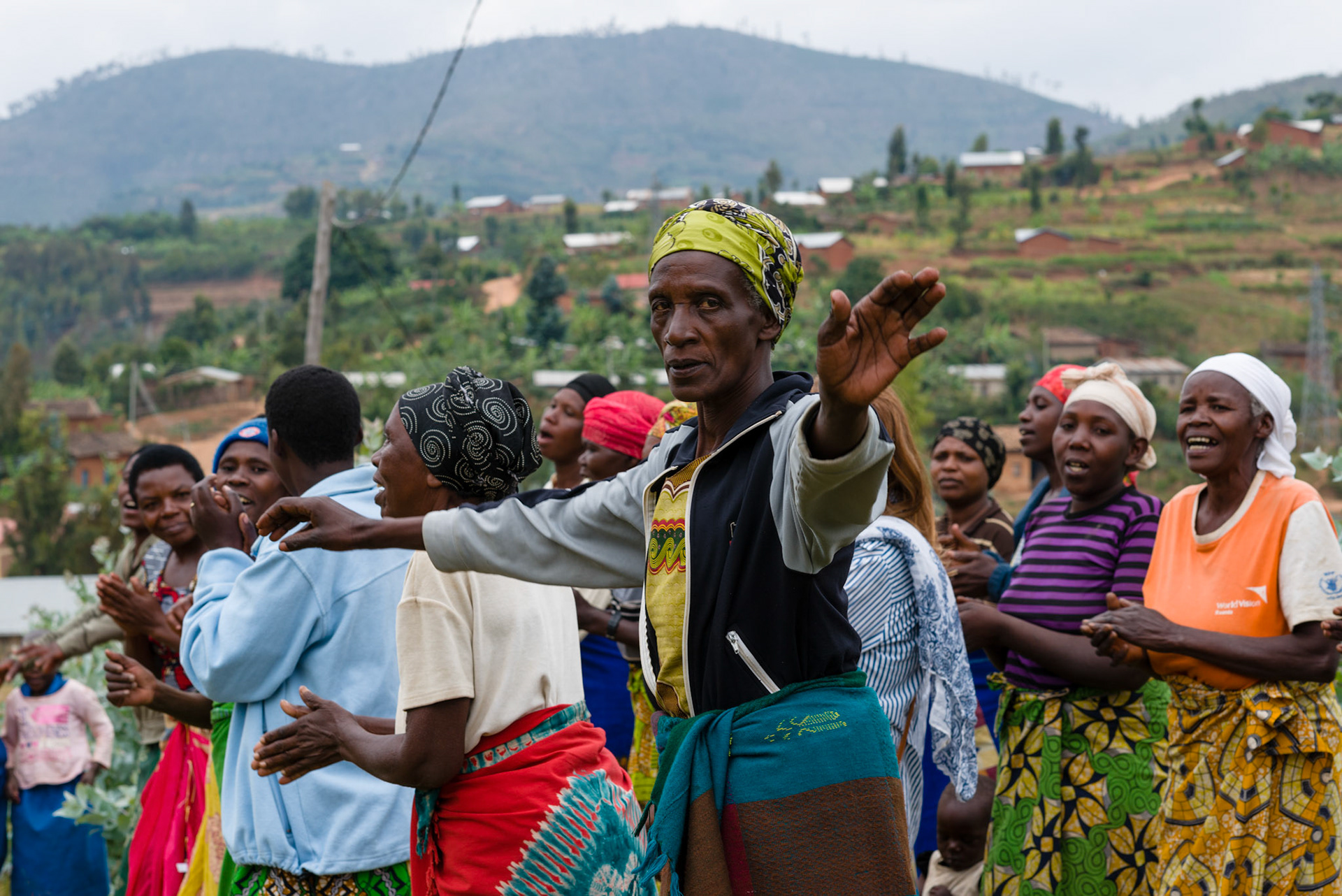 Alivera dances with the women to welcome the District Executive Secreatary and the Cell leader to a special combined self-help group meeting.