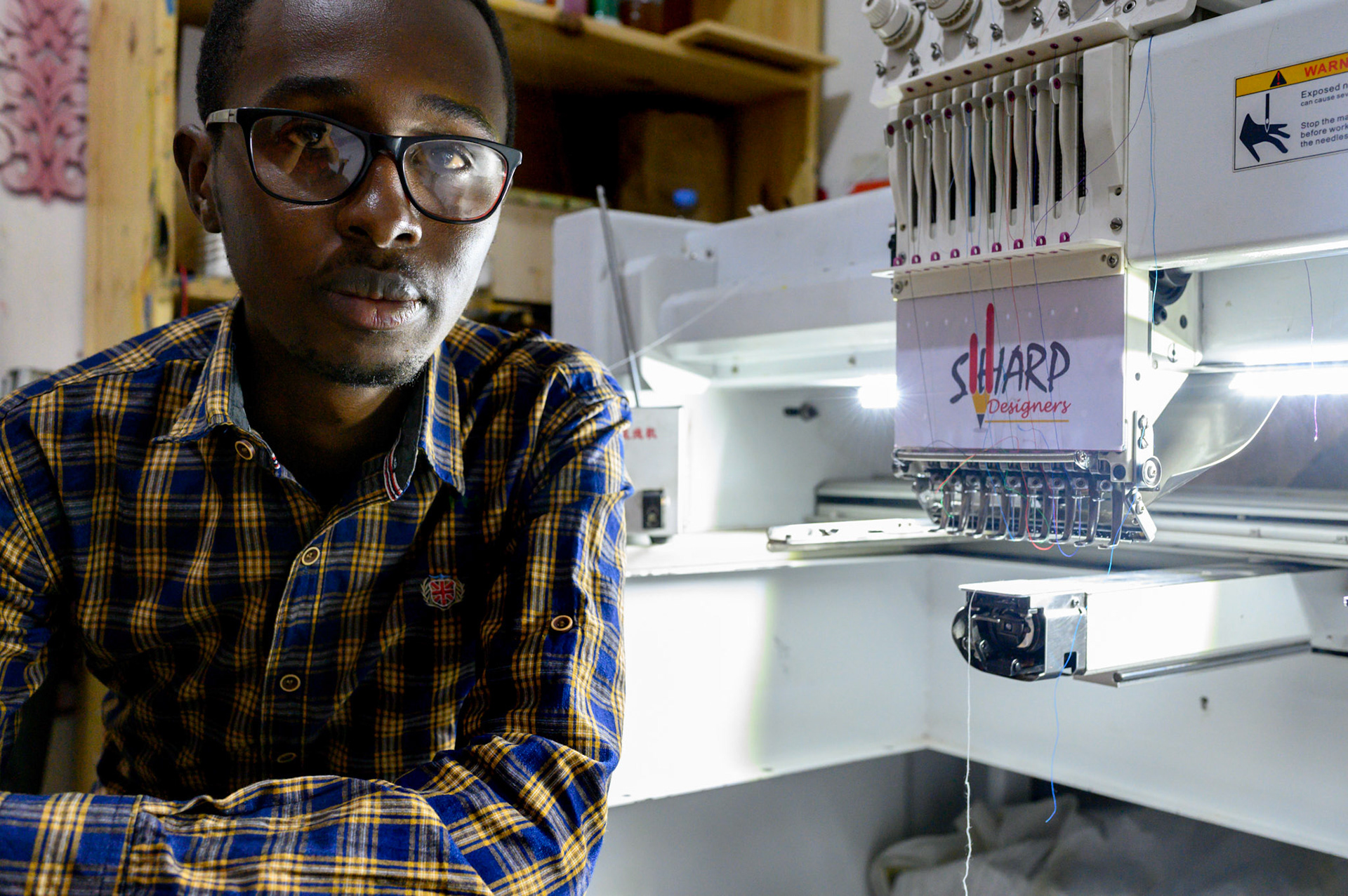 Fiston comes from a fmaily of graphic designers. He has leased an machine for emboidering designs onto shirts and t-shirts. In the first month he has found ten new customers.