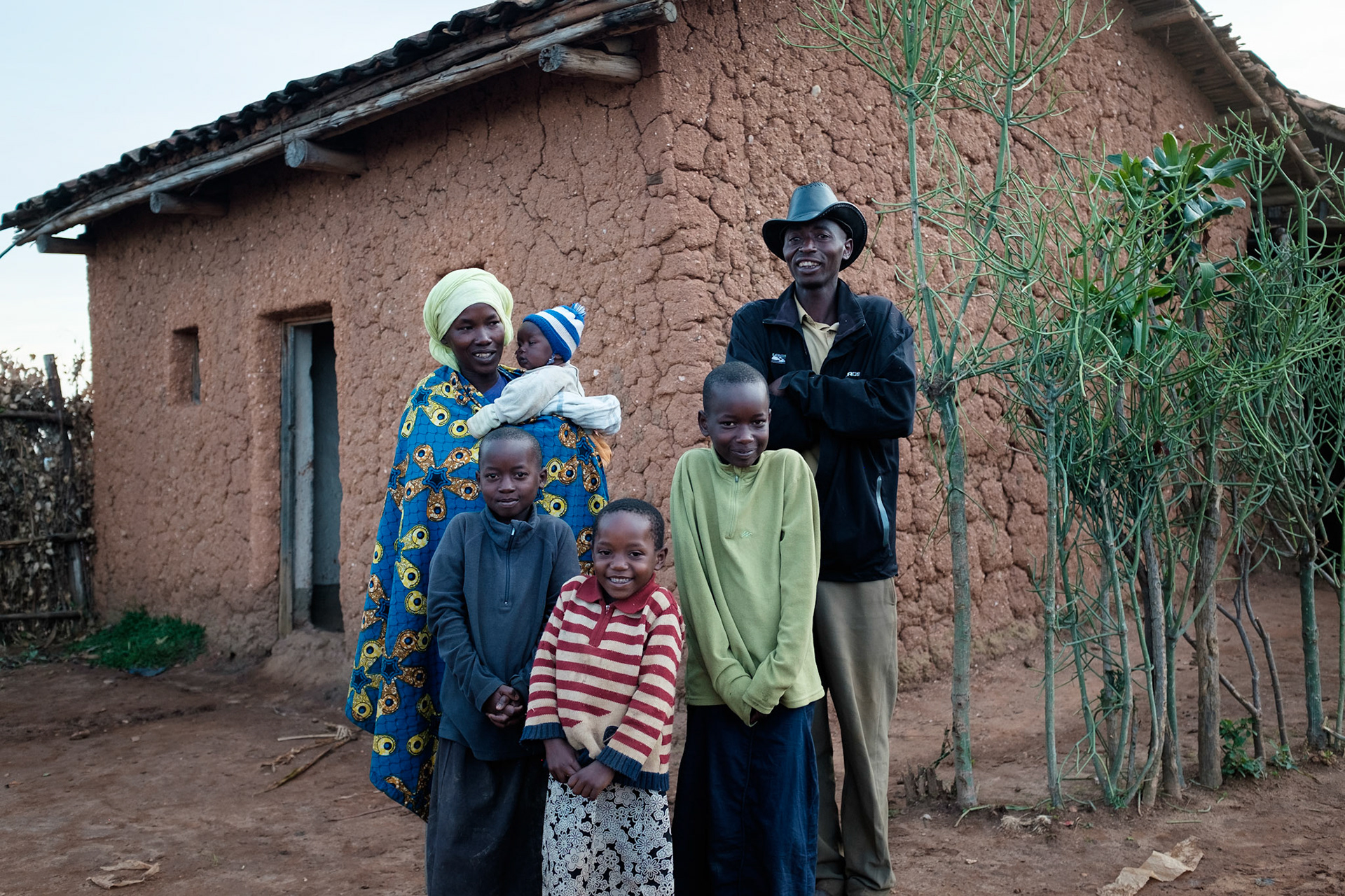 Immaculate's family outside their house. From left-to-right: Immaculate with baby Clarisse, Tuyizre 9, Sandrinn 5, Denise 11, and her husband Emmanuel.