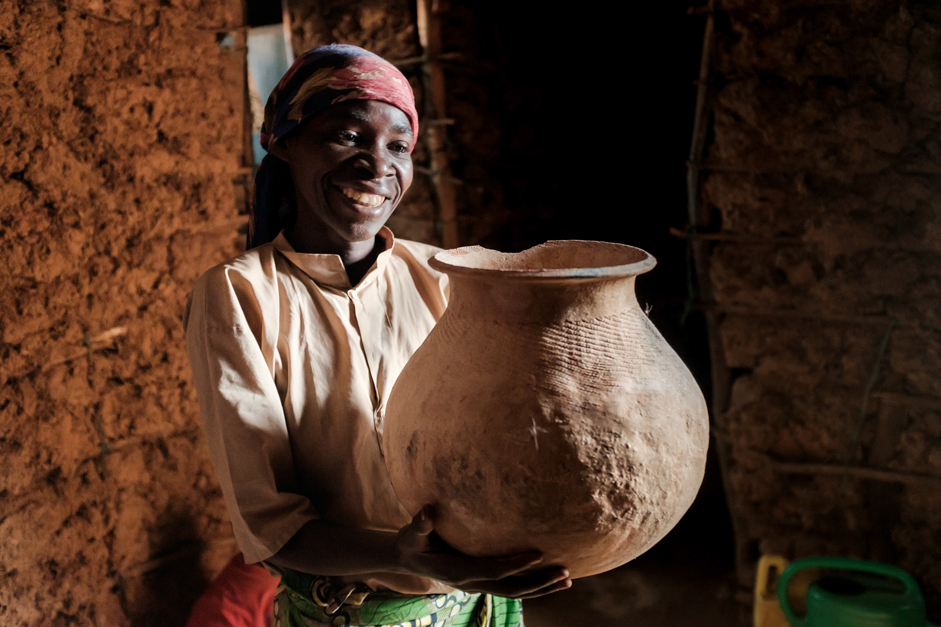 Philomene with a finished pot.
Making clay pots is a traditional craft for Twa; however the demand for pots has largely been displaced by plastic and meta. She can sell her pots for only twenty or thirty US cents each.