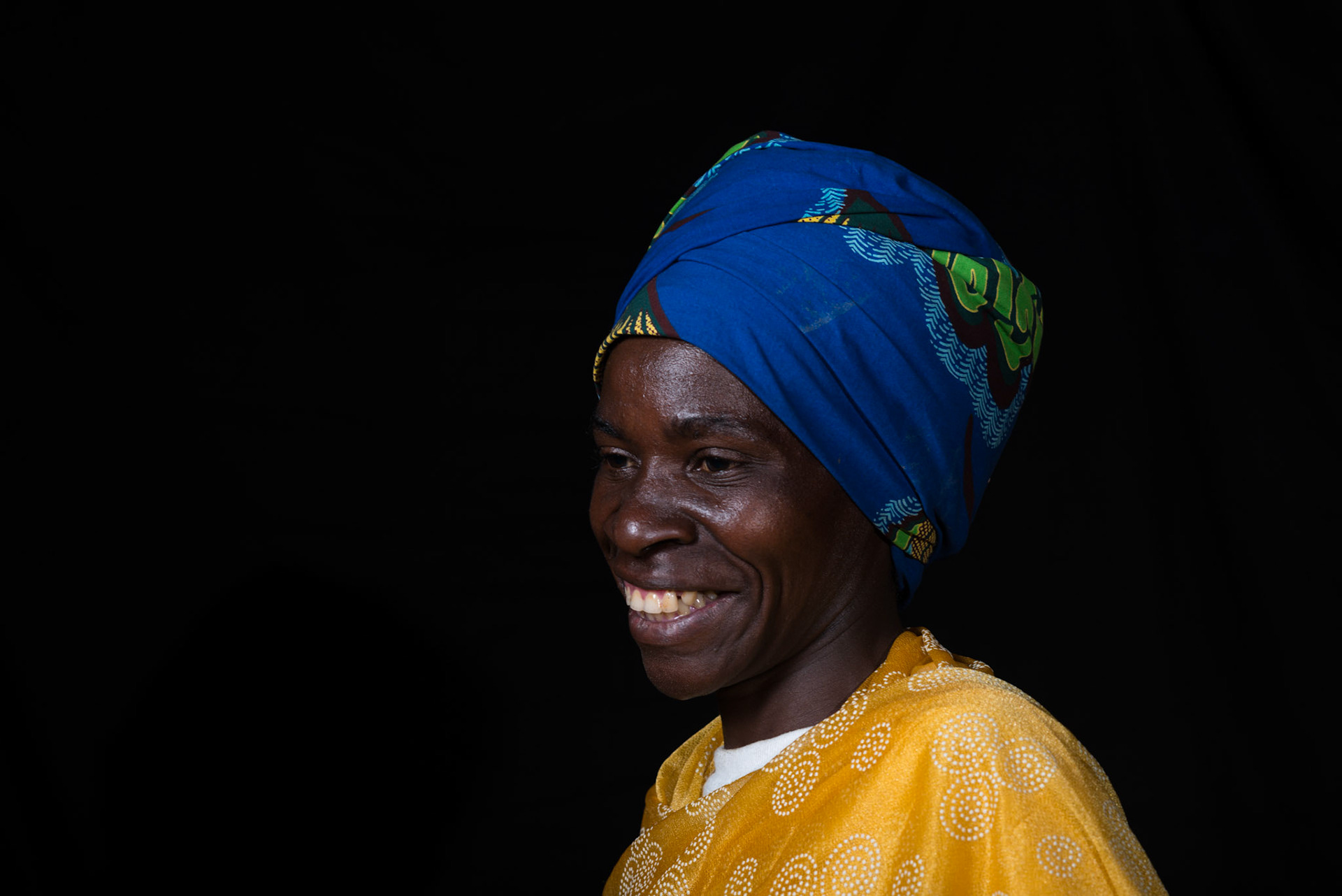 A year after joining her self-help group, Philomene sat for a portrait. She brought the basket to signify the shop she one wants to open.