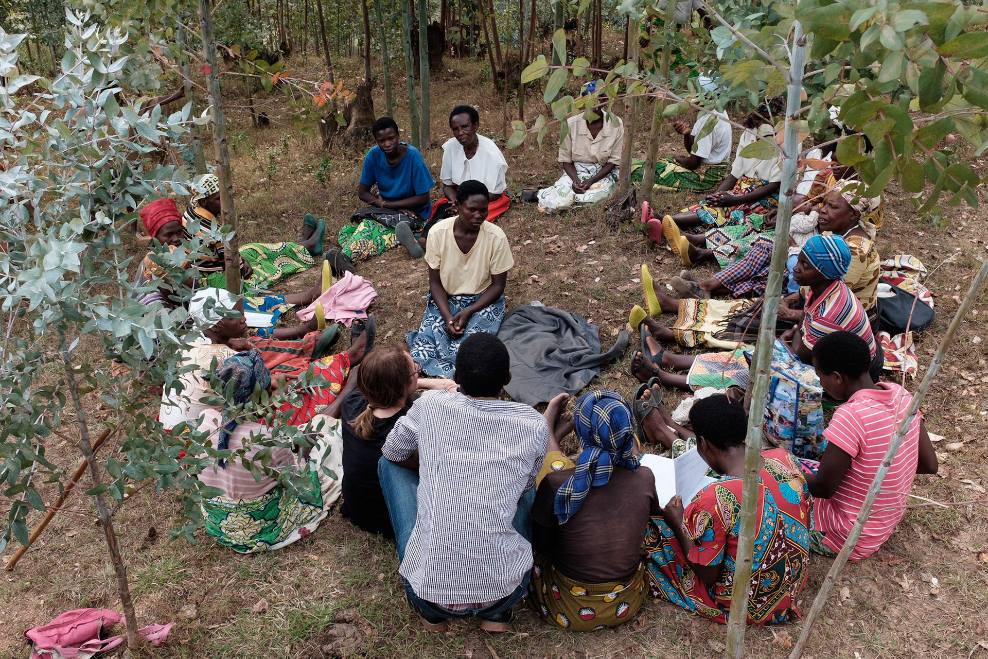 One year on, Ancille sits with her self help group (white shirt at back)