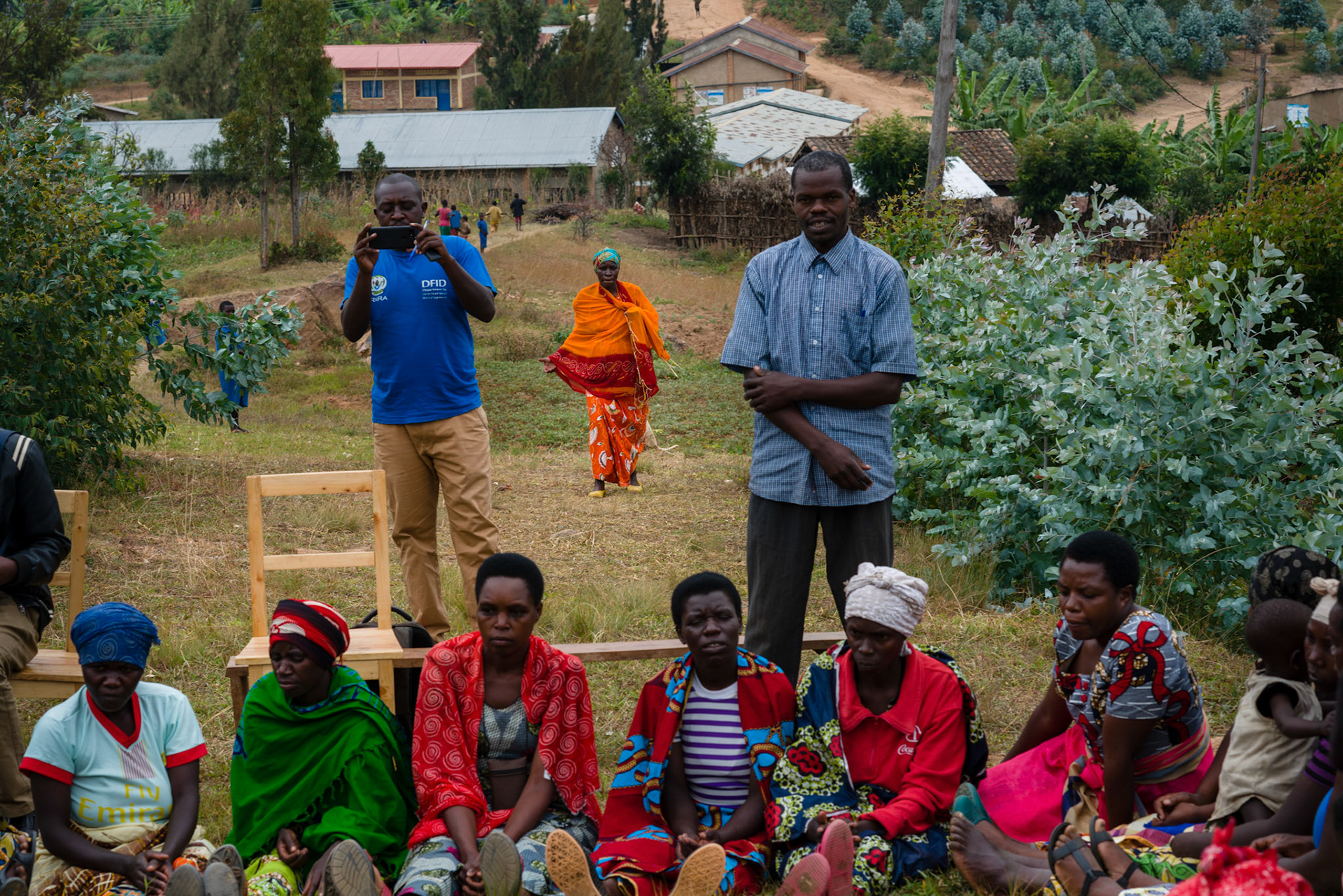 Philomene, in orange, arrives at the meeting of her Kasebuturanyo self-help group.
She is now the group's accountant, something she says that she could never have imagined: going into a bank and talking to the people there.