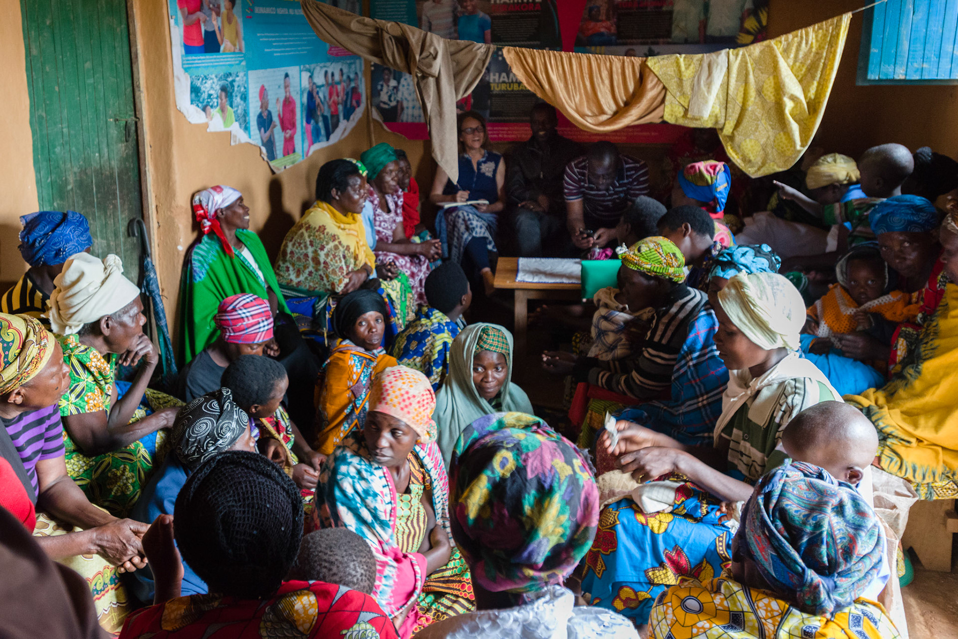 With rain outside, the women hold a combined self-help group meeting in a house.