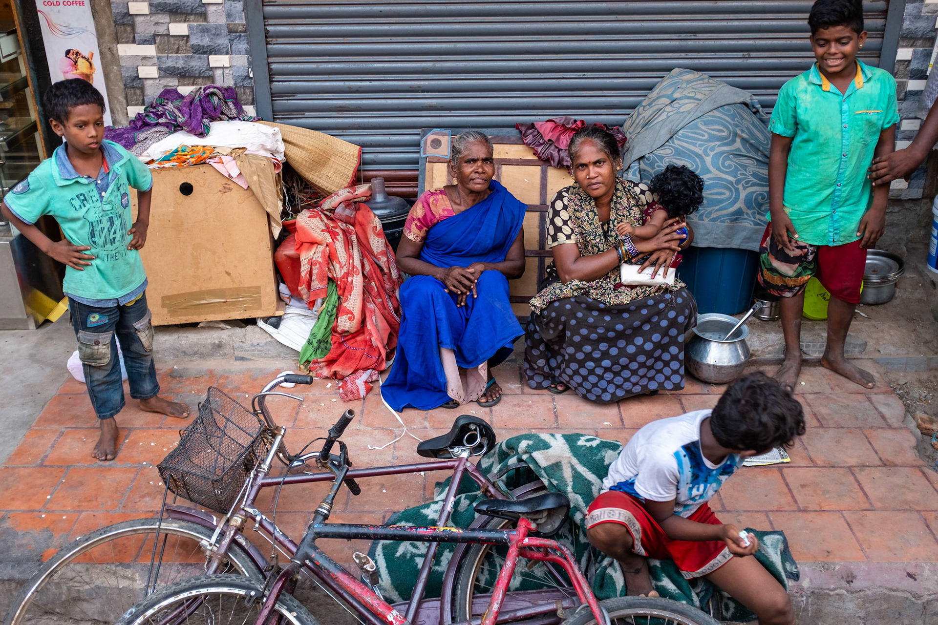 This is the patch of pavement where
Sasikala, 34 (left) lives with her mother Selvakumari, 65 (right), her husband, and her children. 
Saskikala was born on this pavement, as were her three children, aged from seven months to five years.
Sasikala works as a cleaner, and goes to her sister's house to wash. Her husband works as a chai-walla.
She says that if she could get a house, she would live there but still work in this area where she has contacts.