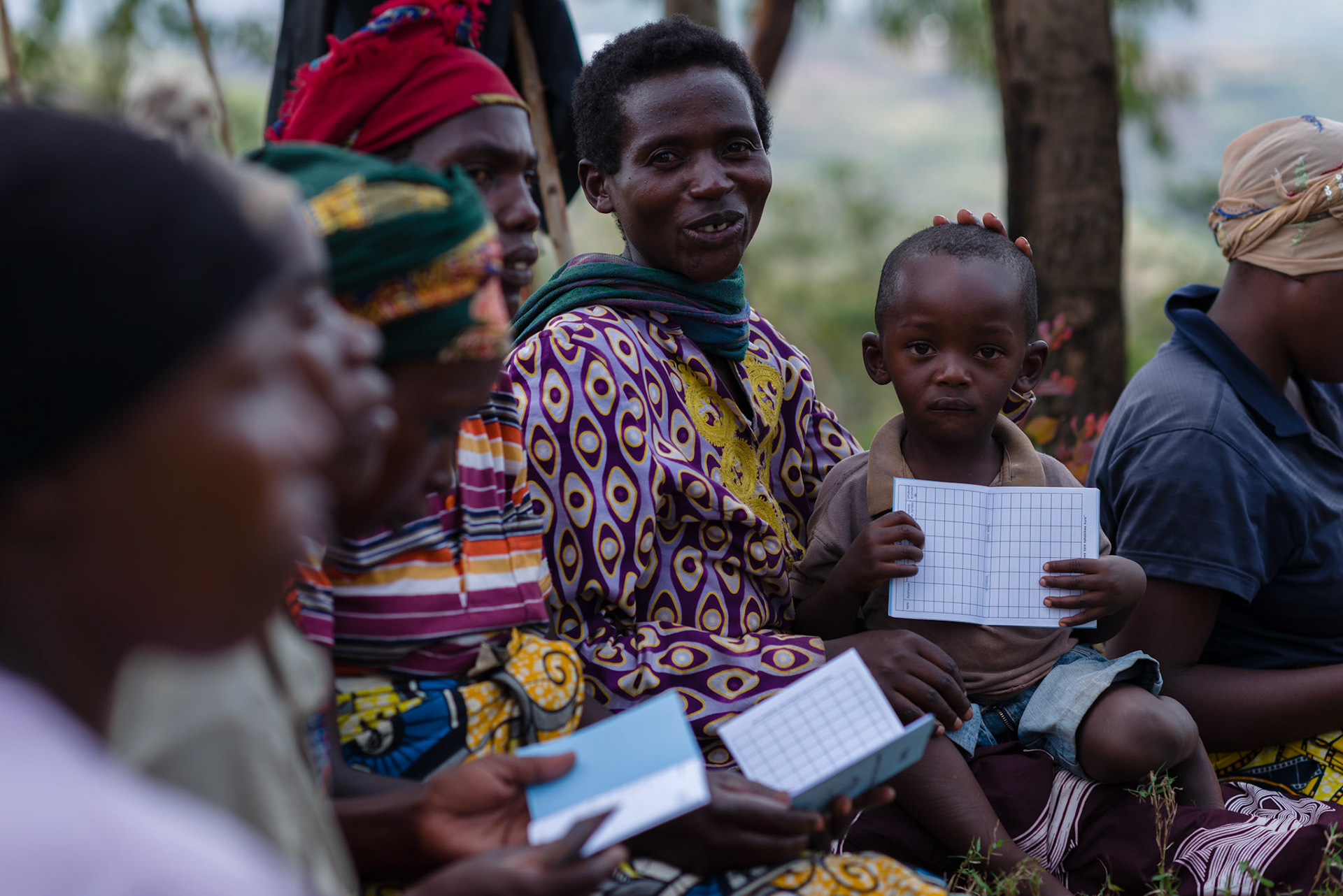 A child holds his mother's new self help group savings and loan book