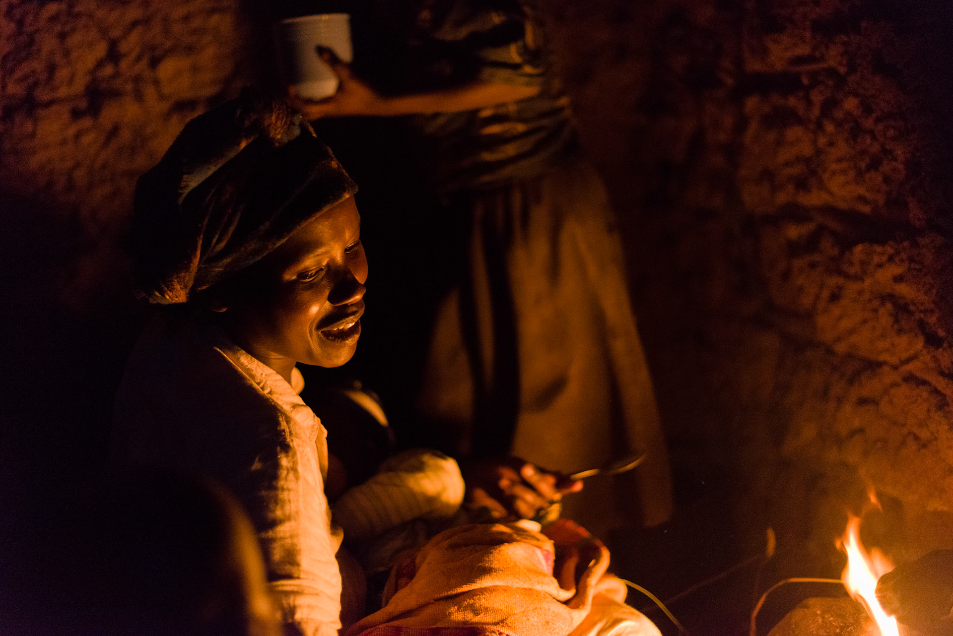 Immaculate prepares a dinner of cabbage in the evening. This is the family's only meal of the day.
By the time Immaculate starts to cook, the sun has set and the fire is the only illumination.