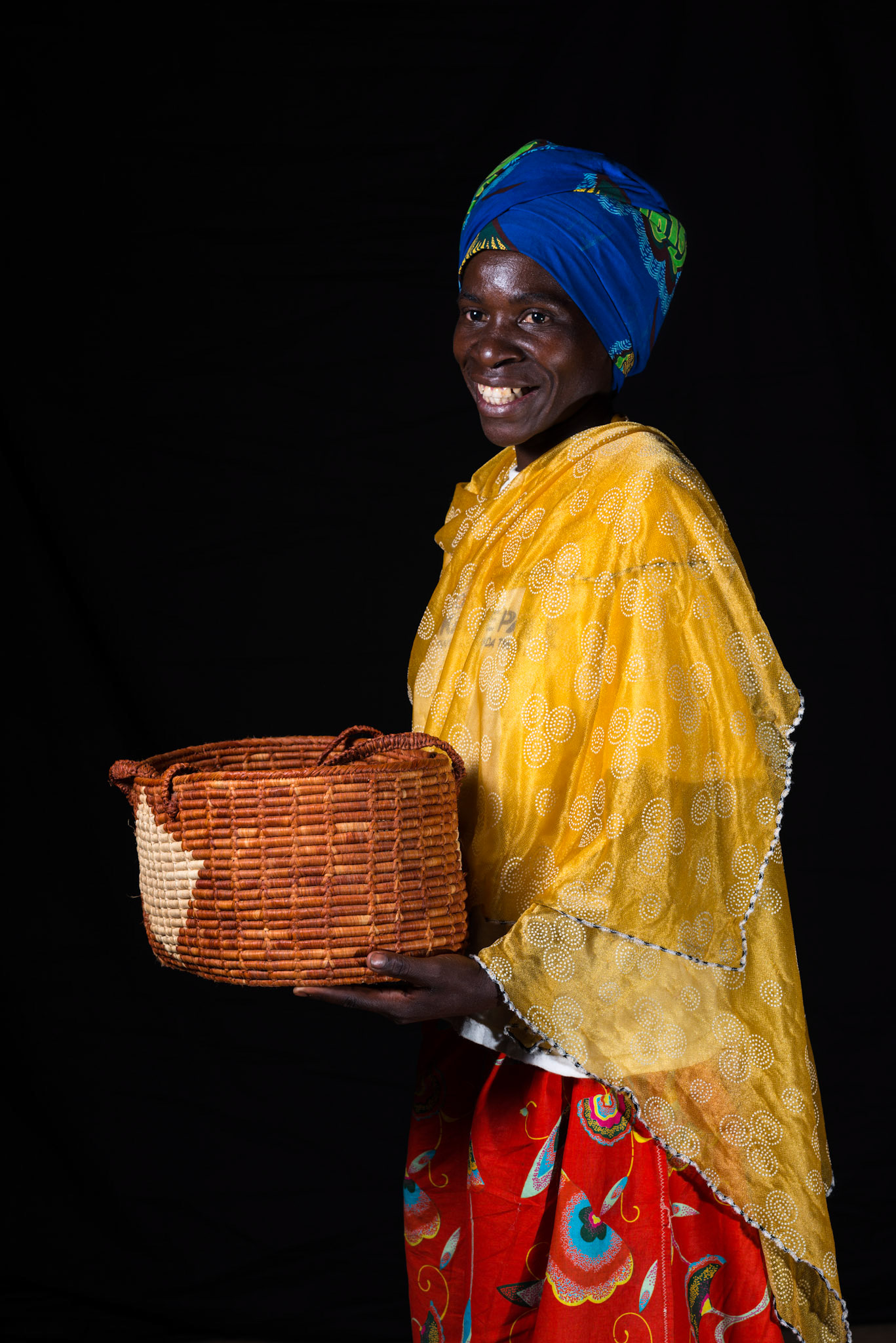 A year after joining her self-help group, Philomene sat for a portrait. She brought the basket to signify the shop she one wants to open.