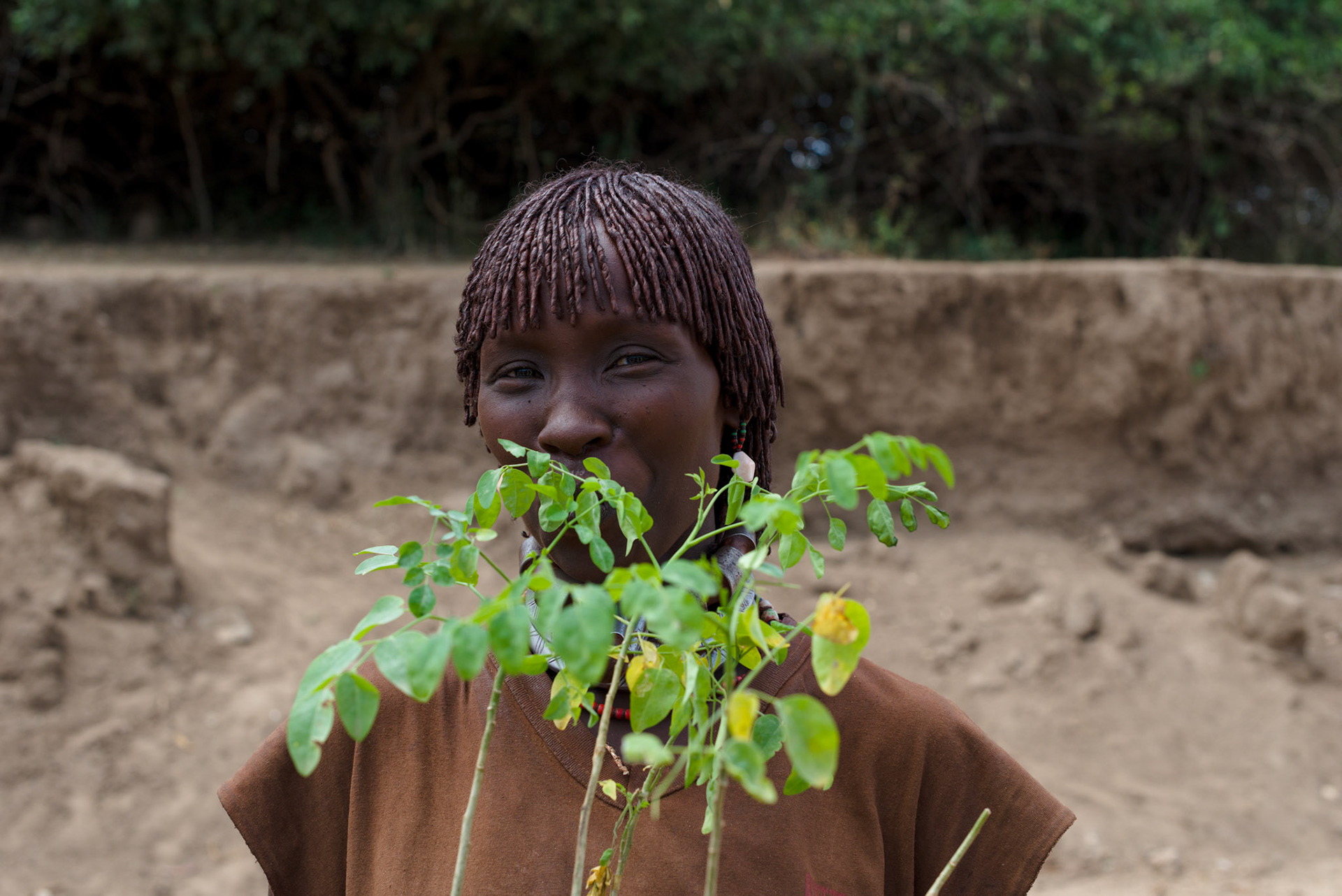 A widow from a nearby homestead with her moringa plants. The seed pods from moringa trees are used for food and as a cash crop.