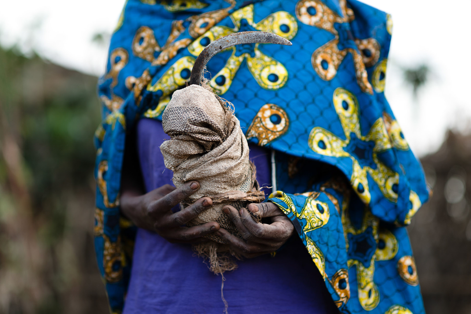 Immaculate goes to cut grass from the hill sides. The grass will be thrown into the cow's pen to mix with manure, and then placed into a pit. The grass and manure mixture will compost and is used as a rich fertilser.