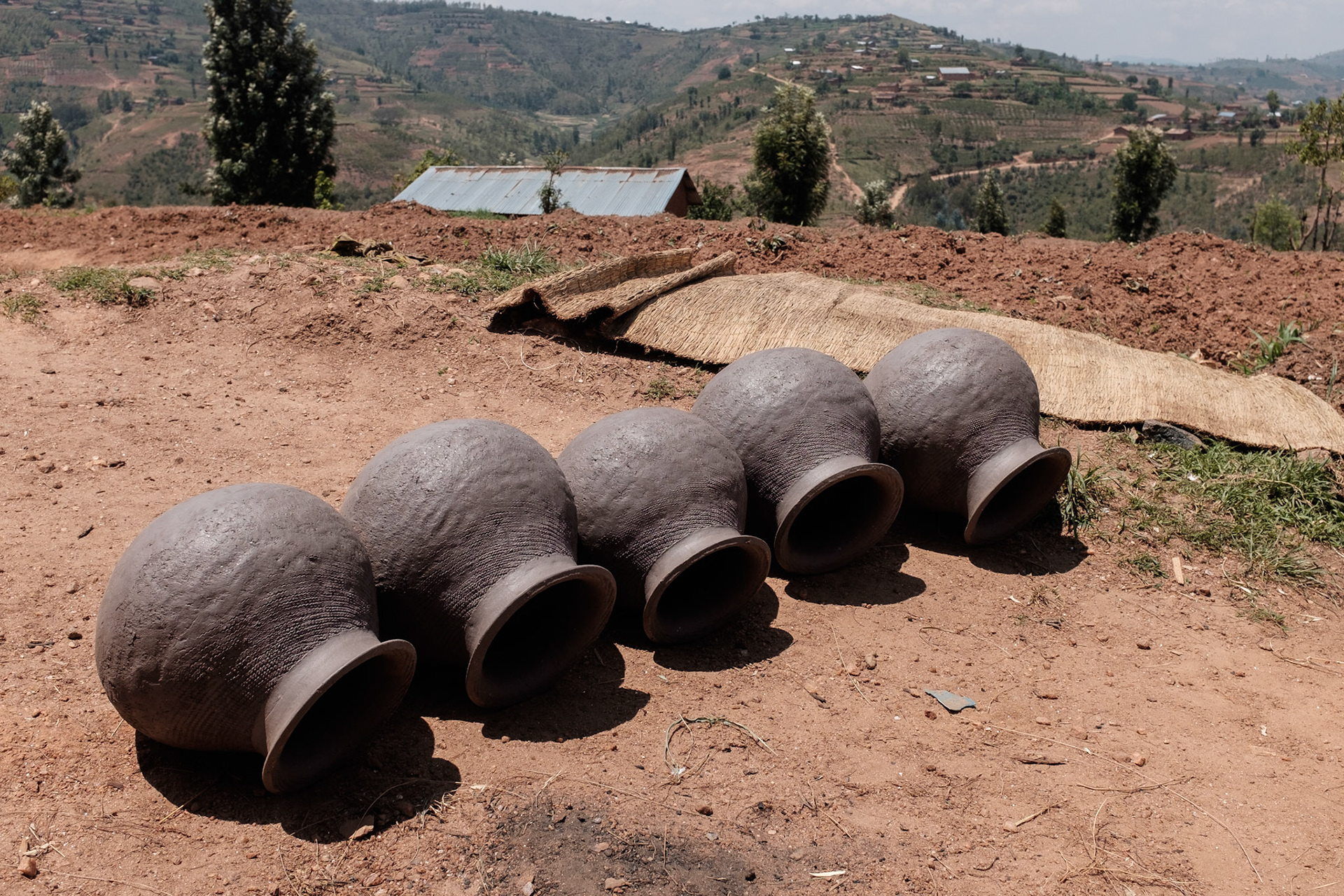 Making clay pots is a traditional craft for Twa; however the demand for pots has largely been displaced by plastic and meta. 
A set of clay pots dry in teh sun, ready for firing.