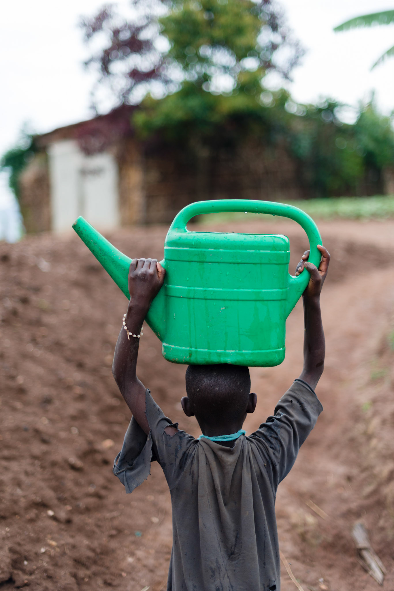 Philomene's daughter Ishimwe, 10, fetches water from deep in the valley. The trip back up to the village might only be ten minutes, but the way is steep and she cannot carry a heavy load. Water is precious., fetches water from deep in the valley.