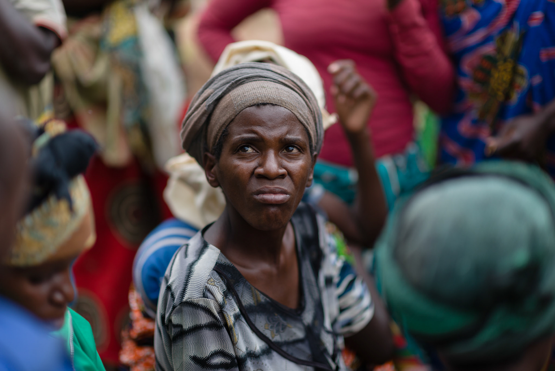A woman sits while groups are being organised. Groups are formed to keep women together of similar economic category and the proximity of their homes.