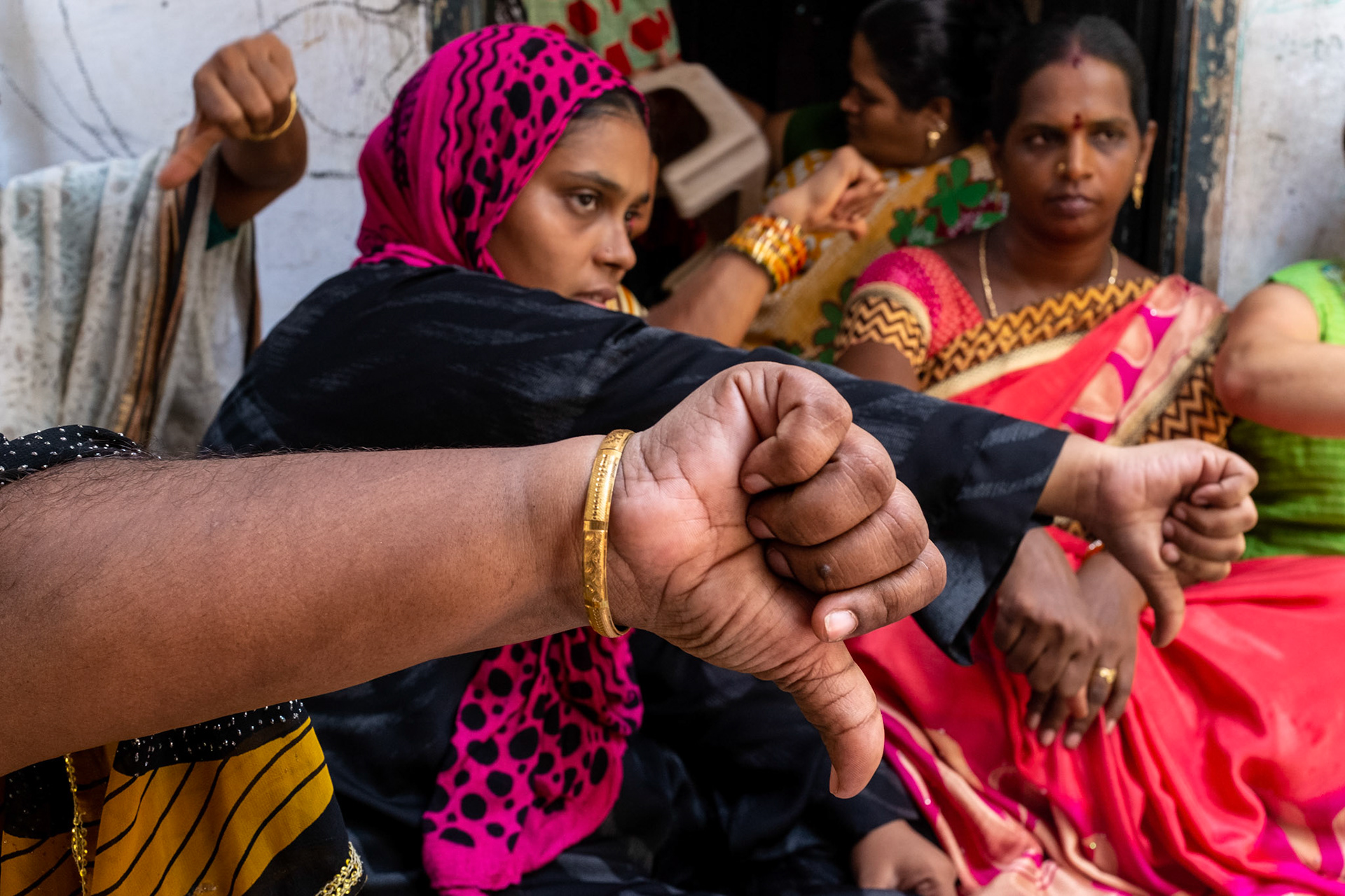 Women in a self-help group use gesture memnomics to learn health and wellbeing training. Here they say "no to alcohol".