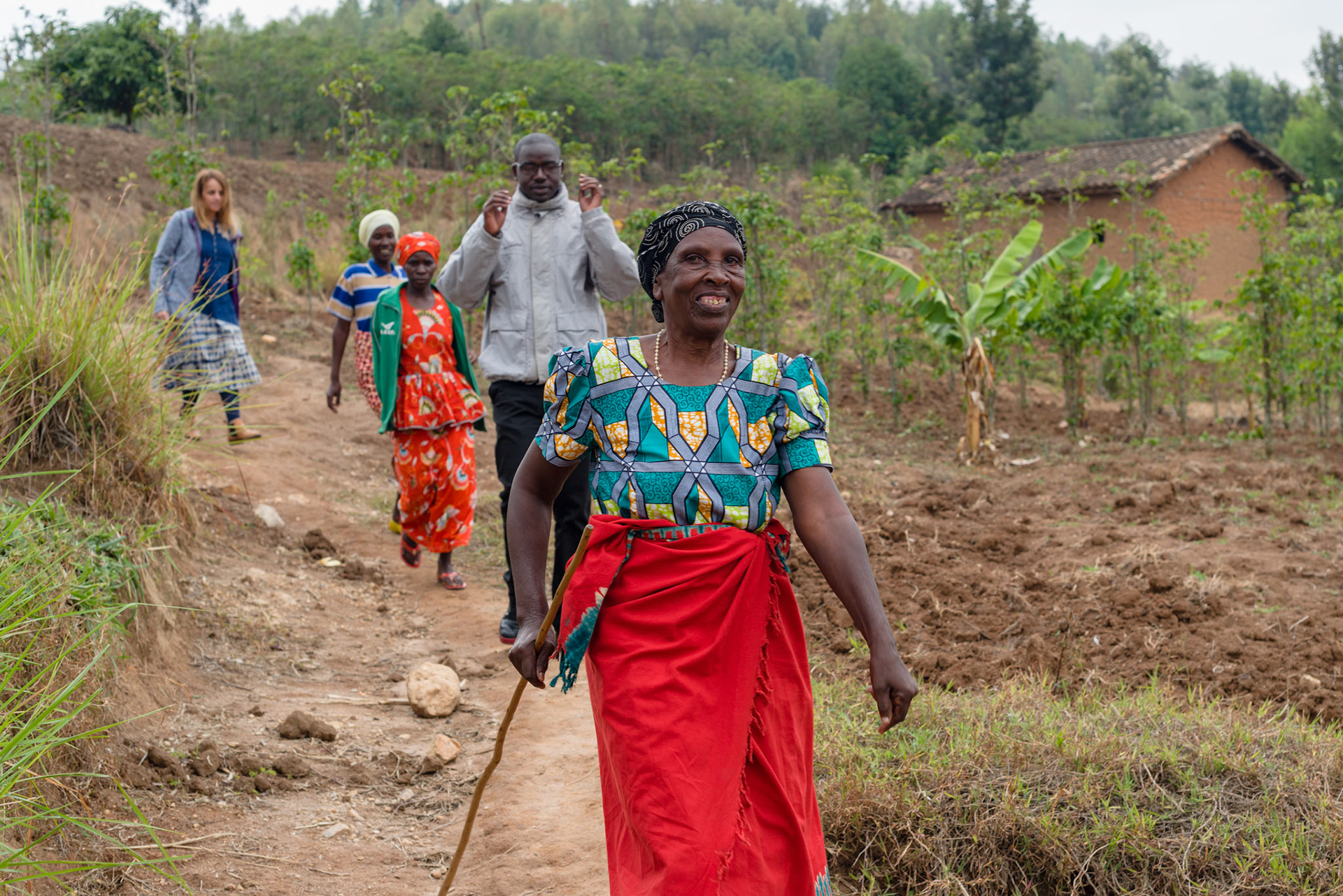 Ancille in 2018, leading the NGO group to her house.
Ancille's health problems have stopped her from working, but she is still happy and is supported by her self-help group.