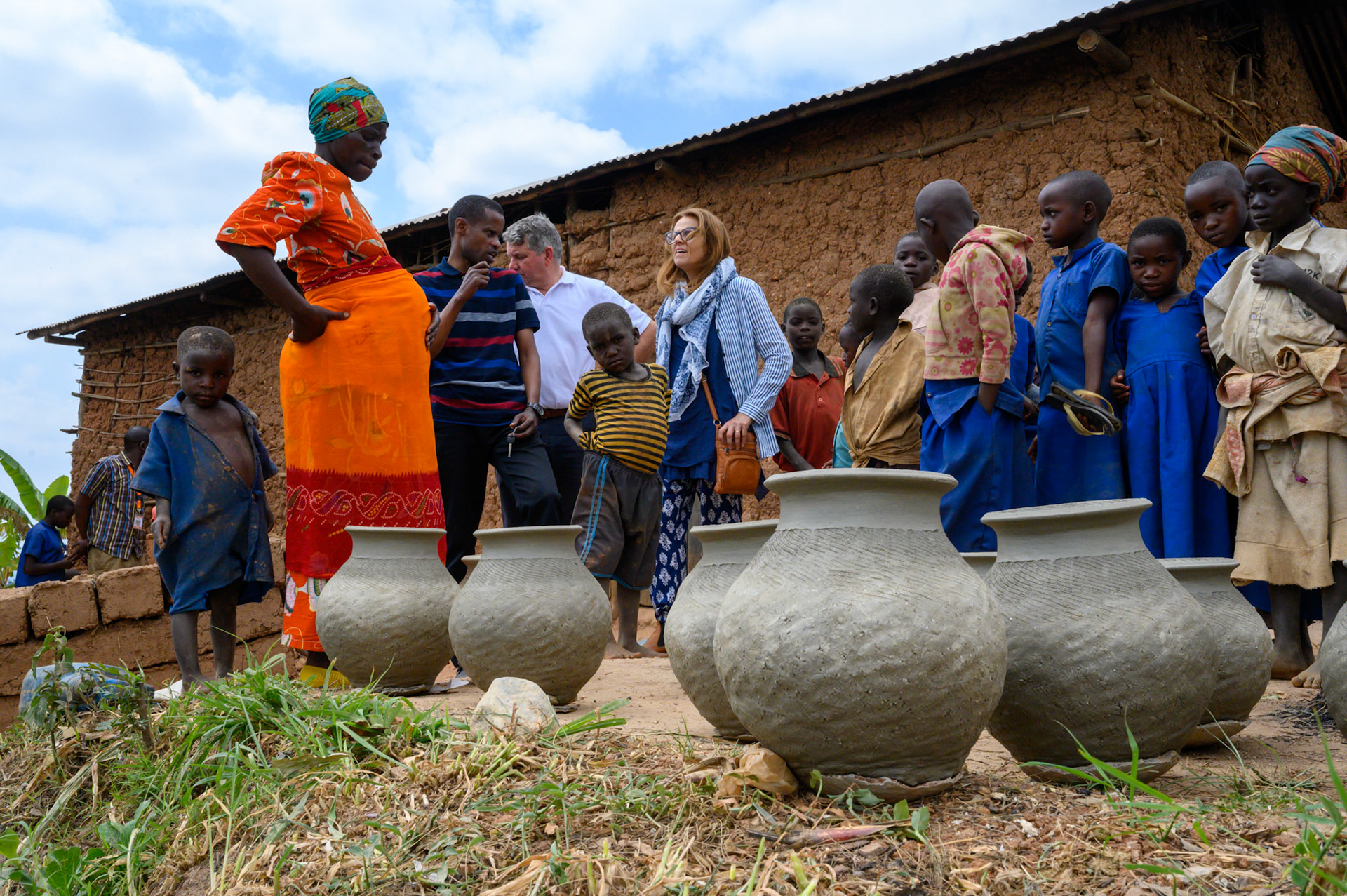 Philomene's stands with pots she has made, ready for firing.

Philomene has resumed making traditional pots, but now also sells avocados at markets, has a pig and raises rabbits.

Philomene is now expecting her fourth child but says she is not concerned, she can afford the extra child.