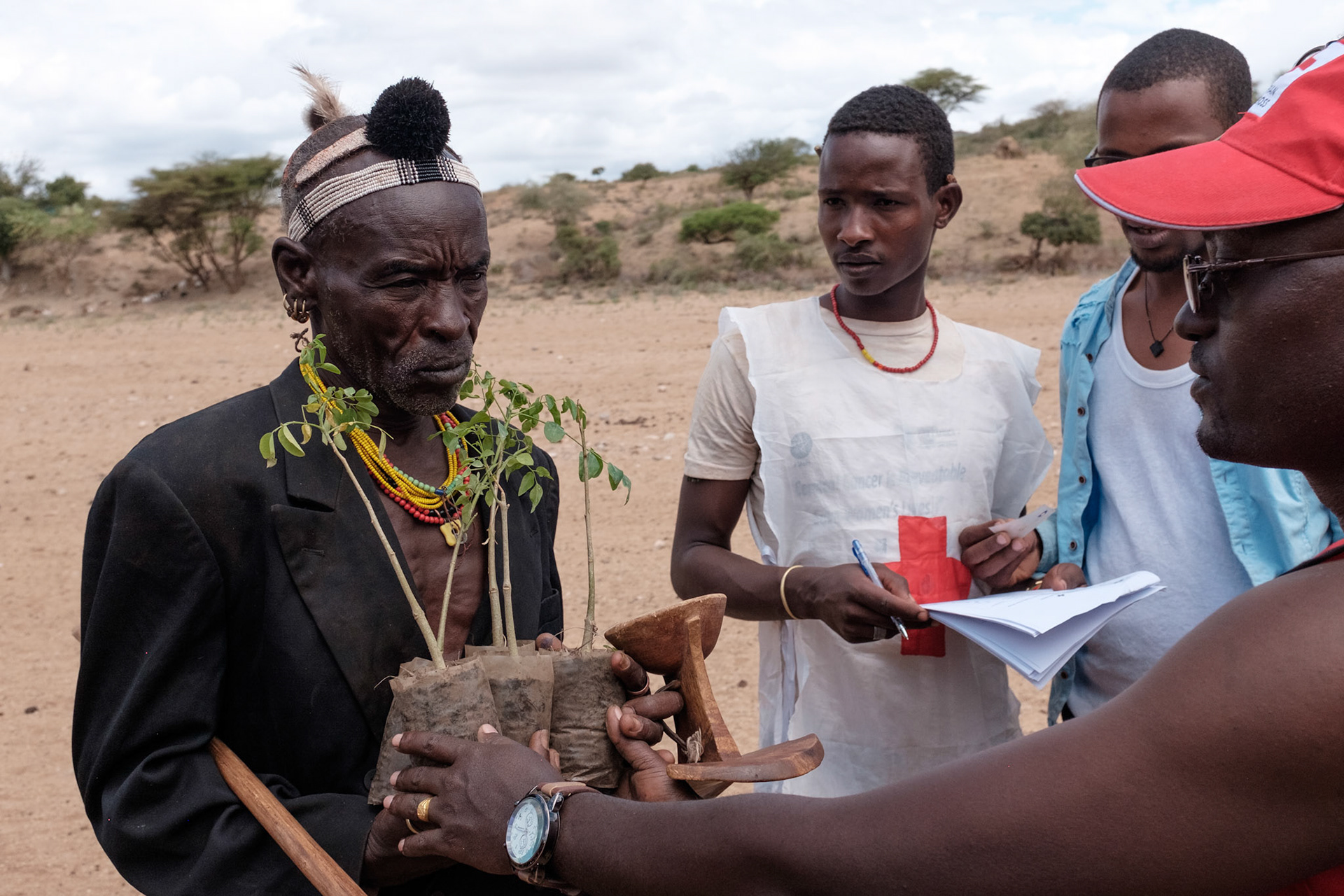 Hamer man Amber Kulo receives his moringa plants from Akna Atana, the South Omo branch project coordinator.