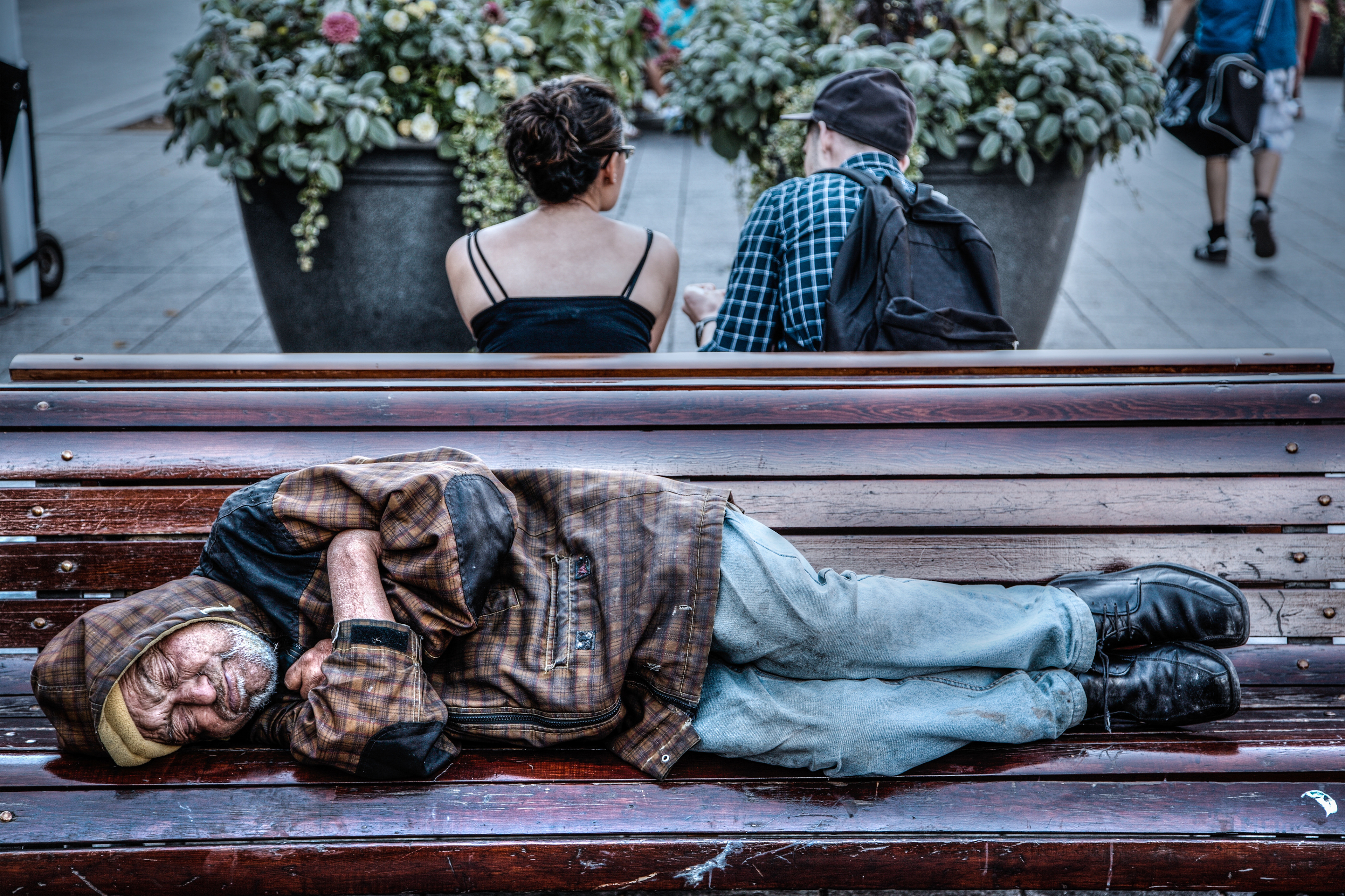 Бездомный спит на скамейке