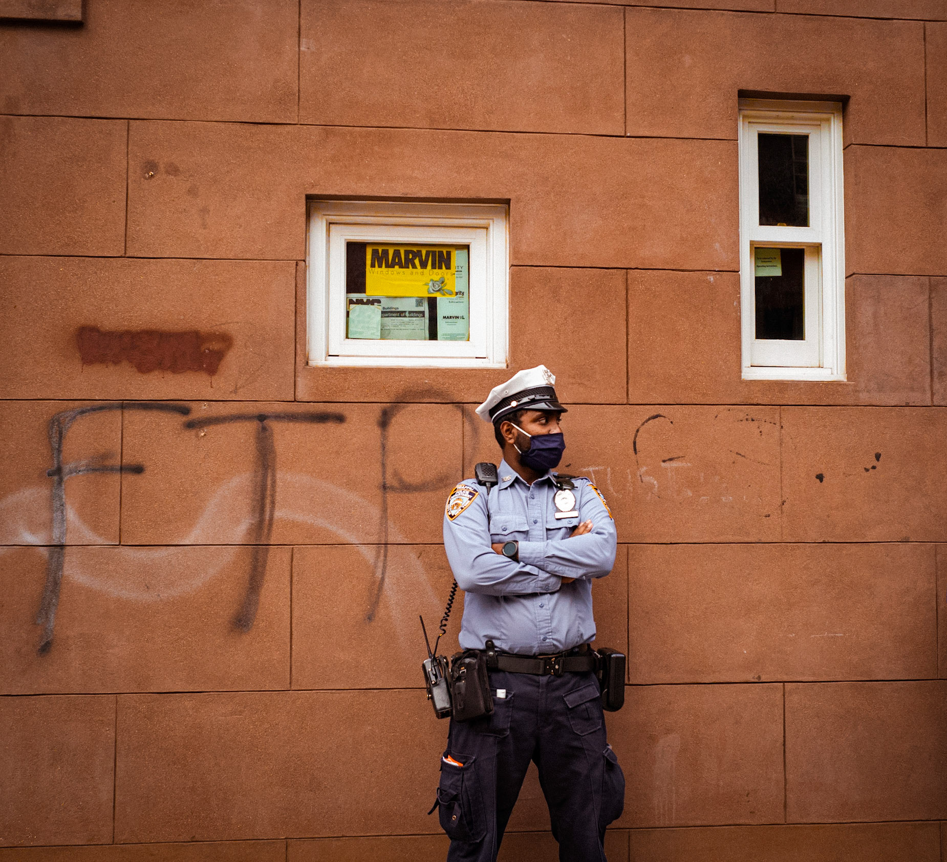 Police officer standing in front of graffiti 