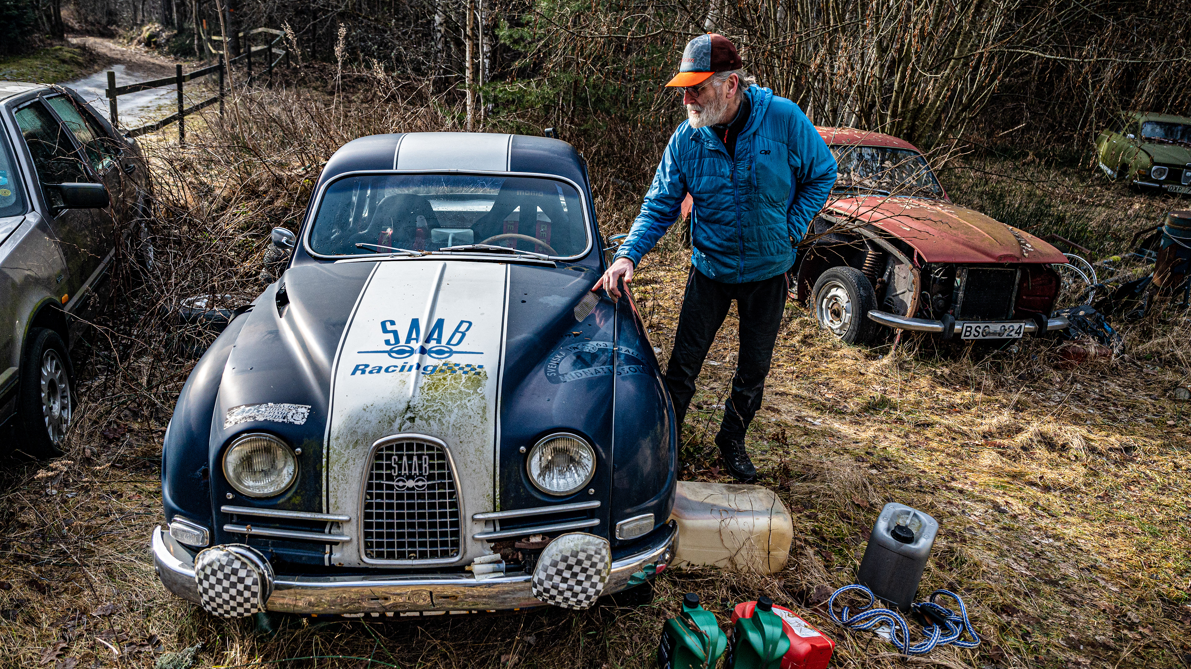 Erik Wallgren pointing out the rally scars on the Saab