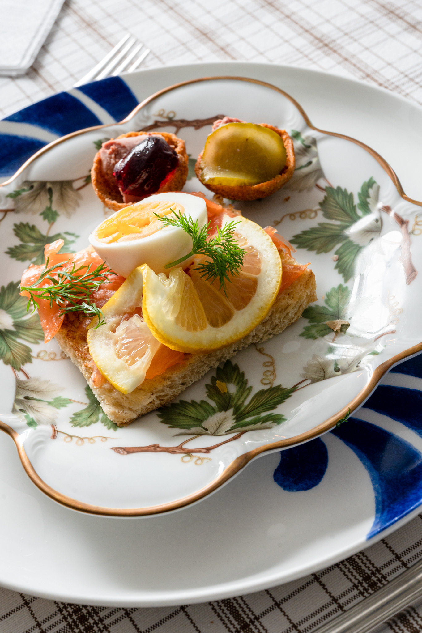 Lax on toast with dill (foreground) and pâté in cups (background)