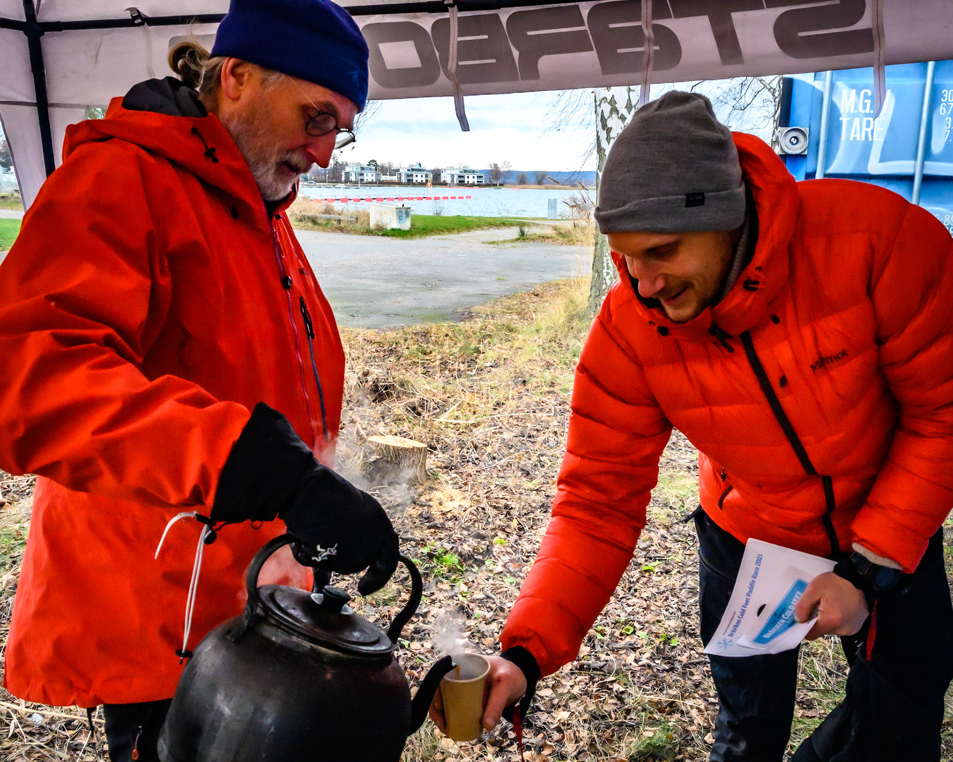 Erik Wallgren pouring hot coffee before the start of the race for stand up paddling athlete Mattias Eriksson.