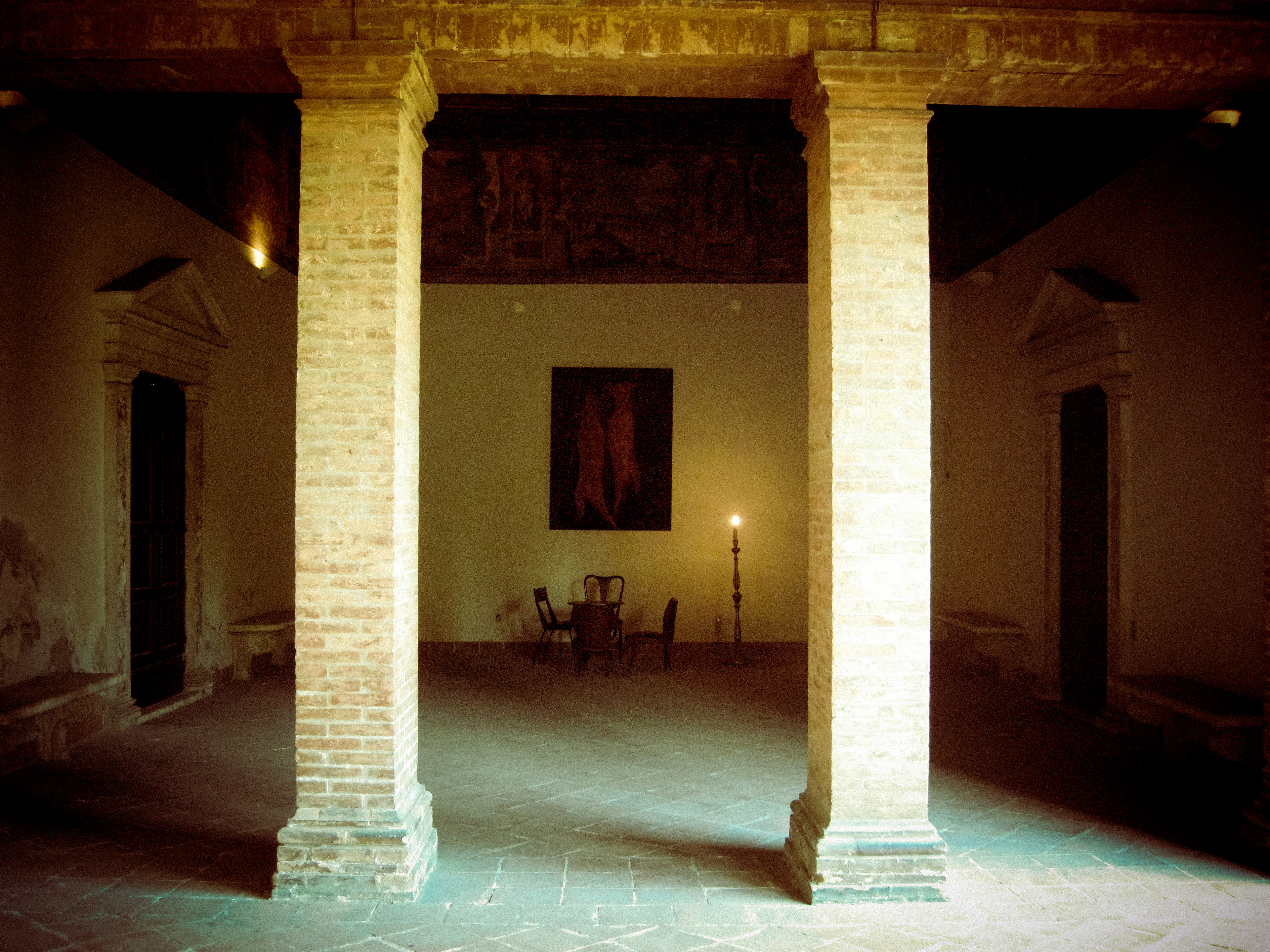 Detail of a part of the installation at Marfisa D'Este garden with a painting and a seance table with chairs and light