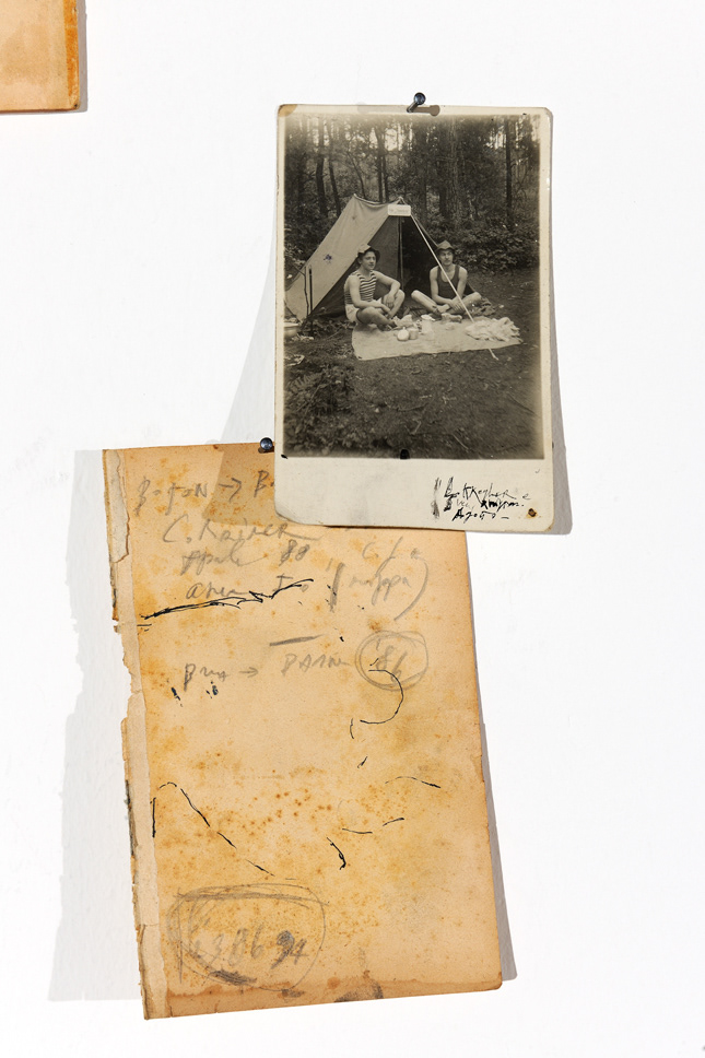 Detail of the installation, vintage paper and picture with two men camping outdoor
