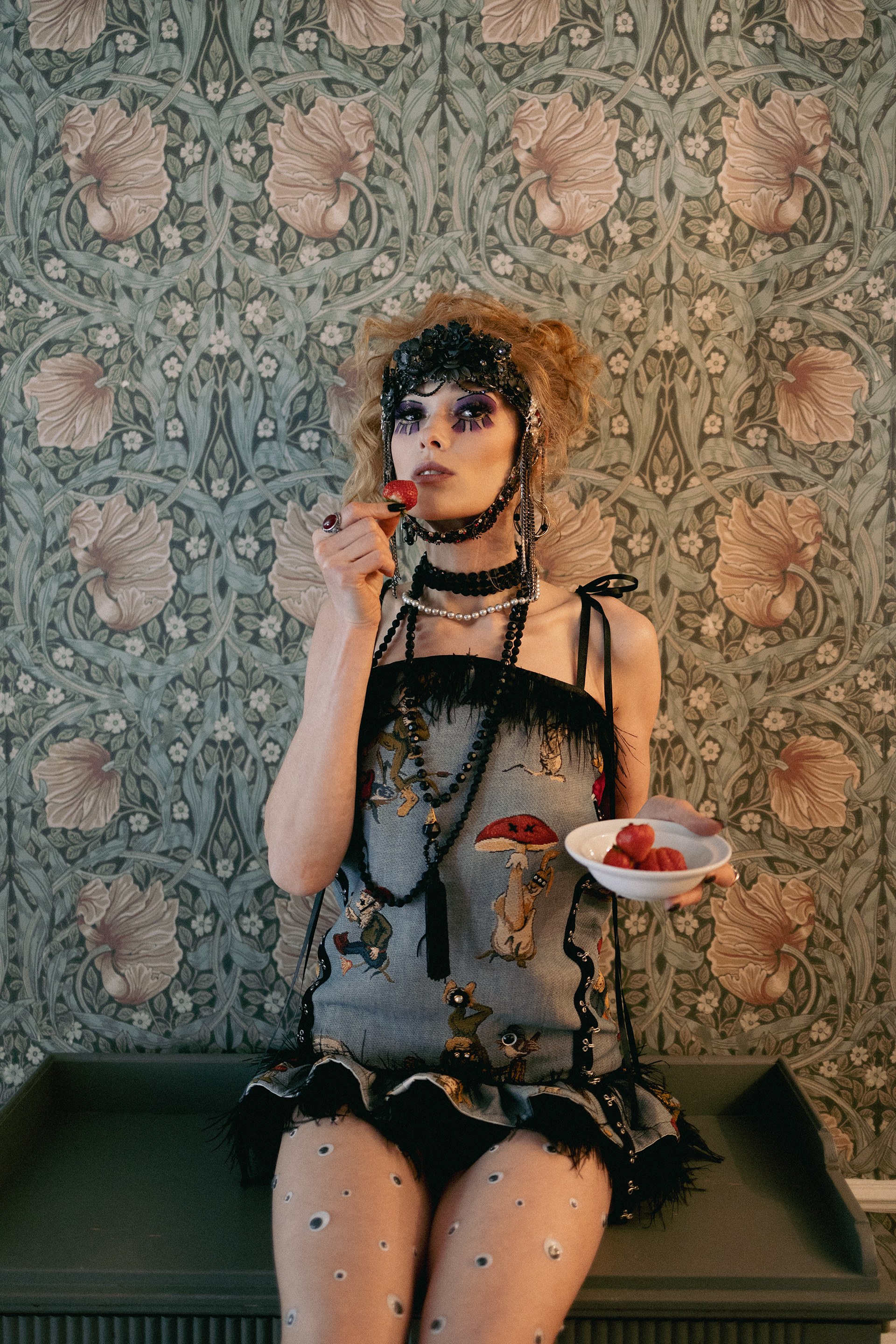 Sasha Sytenko — editorial portrait with berries and patterned wallpaper.